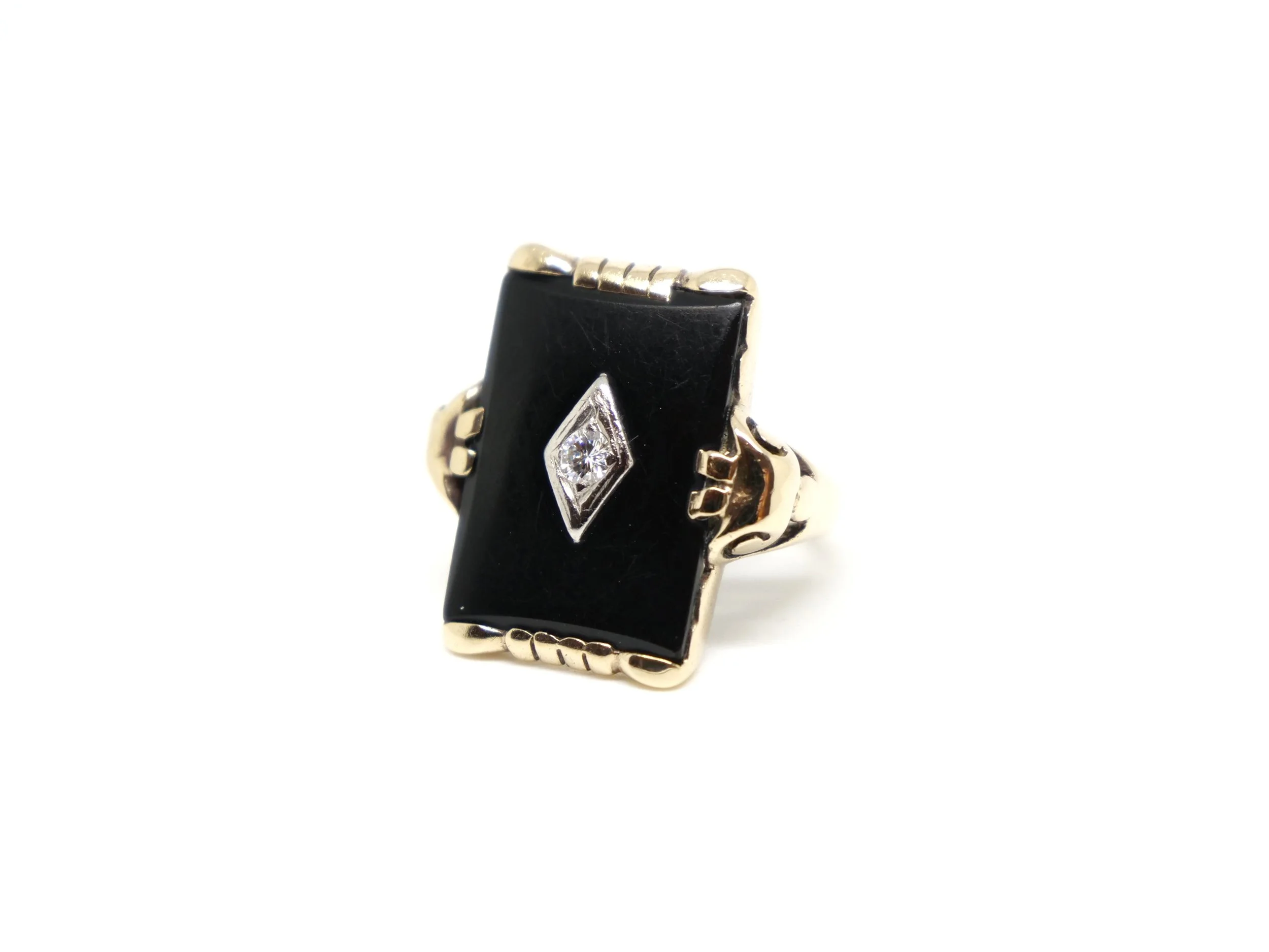 Heavy vintage ring in 10ct gold, with a central diamond set in to rectangular cut onyx. Gold decoration to top and bottom, as well as shoulders.