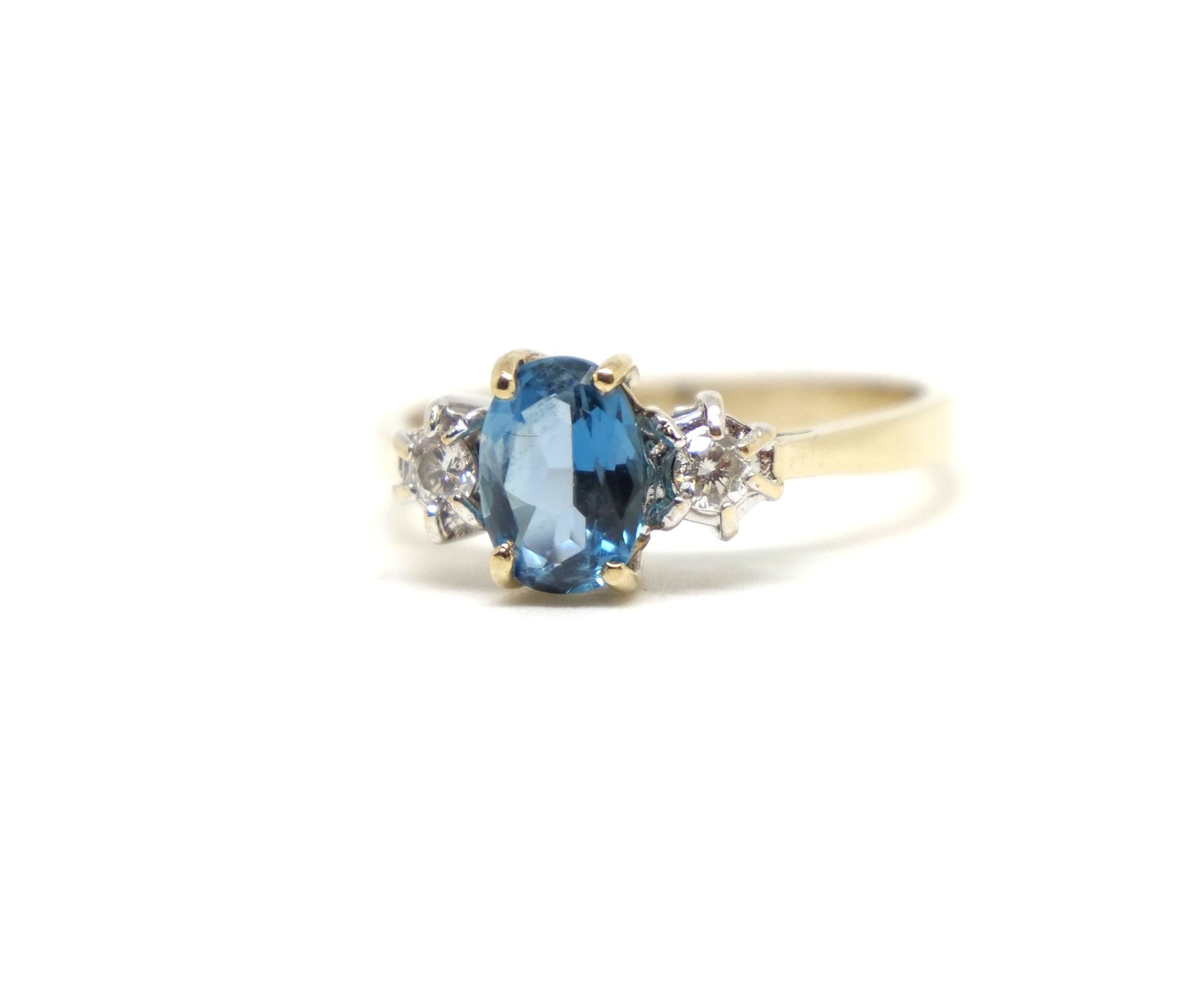 Very pretty blue topaz and diamond three stone ring, set with a central oval cut blue topaz, with a round brilliant cut diamond to each side. Set in 9ct gold.