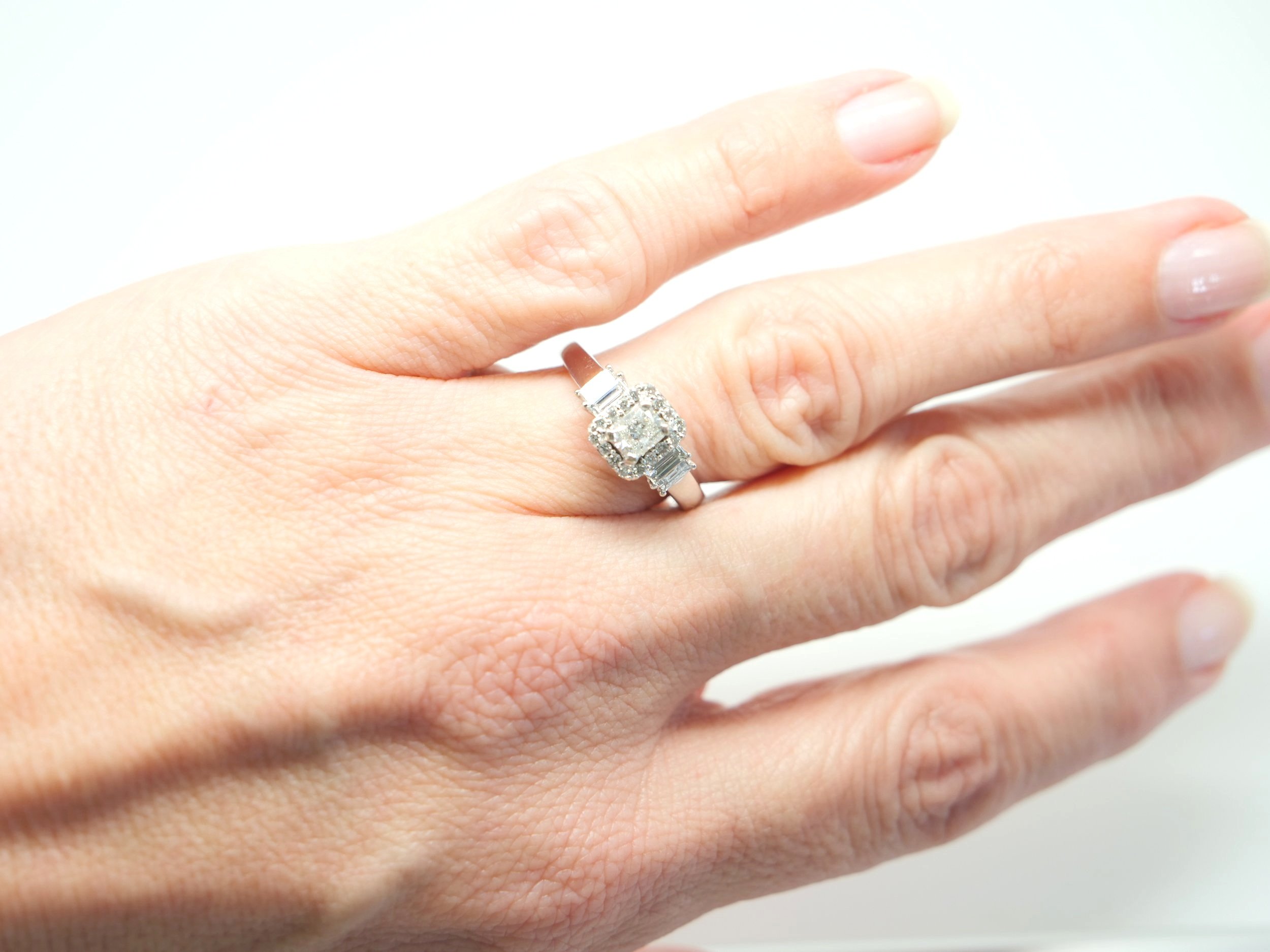 18ct white gold vintage style ring, set with a radiant cut diamond and surrounded by brilliant cut diamonds. Further baguette cut diamonds to each side, with a total of 0.8ct diamonds overall.