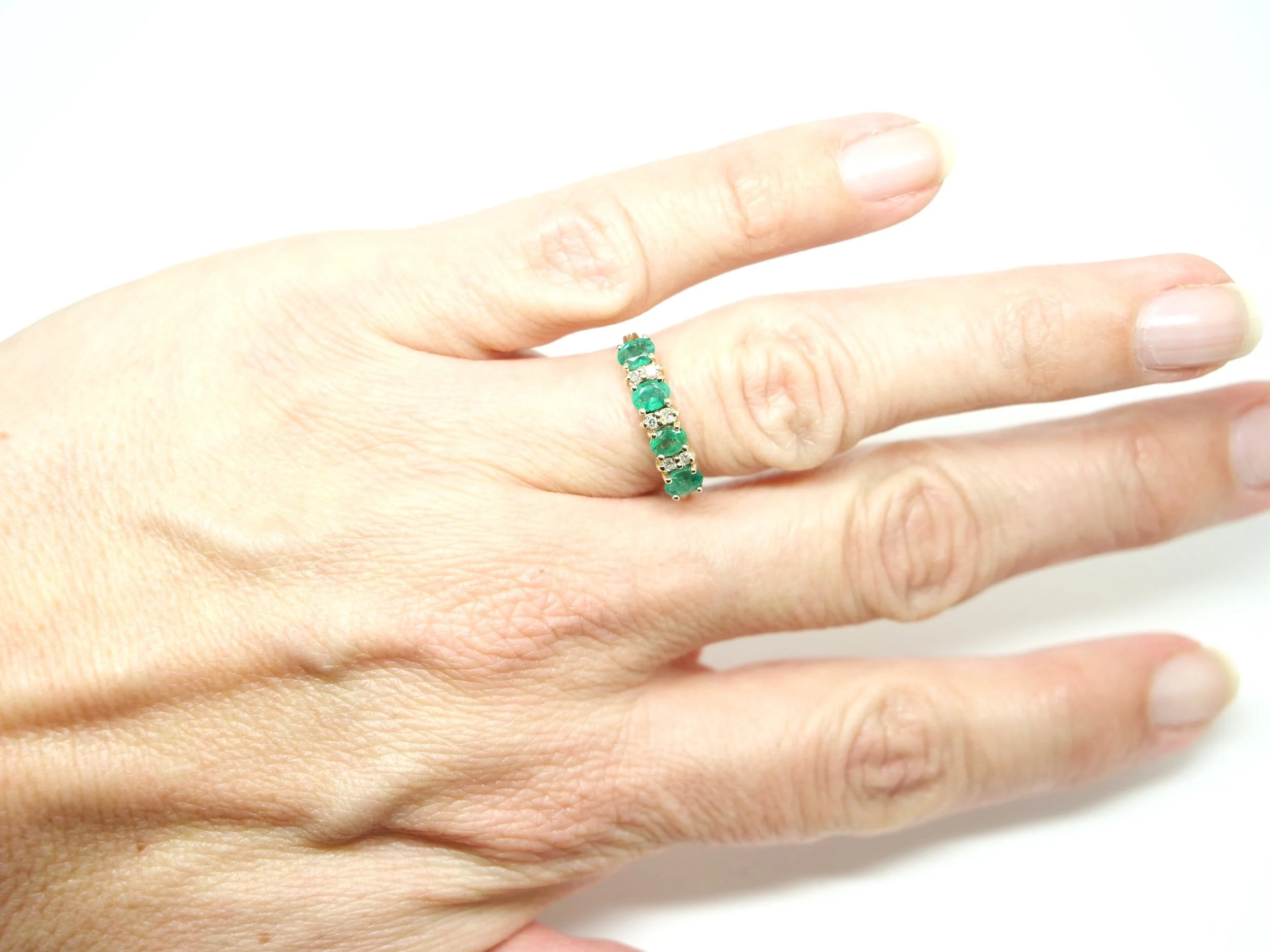 Beautiful emerald and diamond half eternity ring, set with four lovely green oval cut emeralds, with two small diamonds set between each. All in 9ct gold.