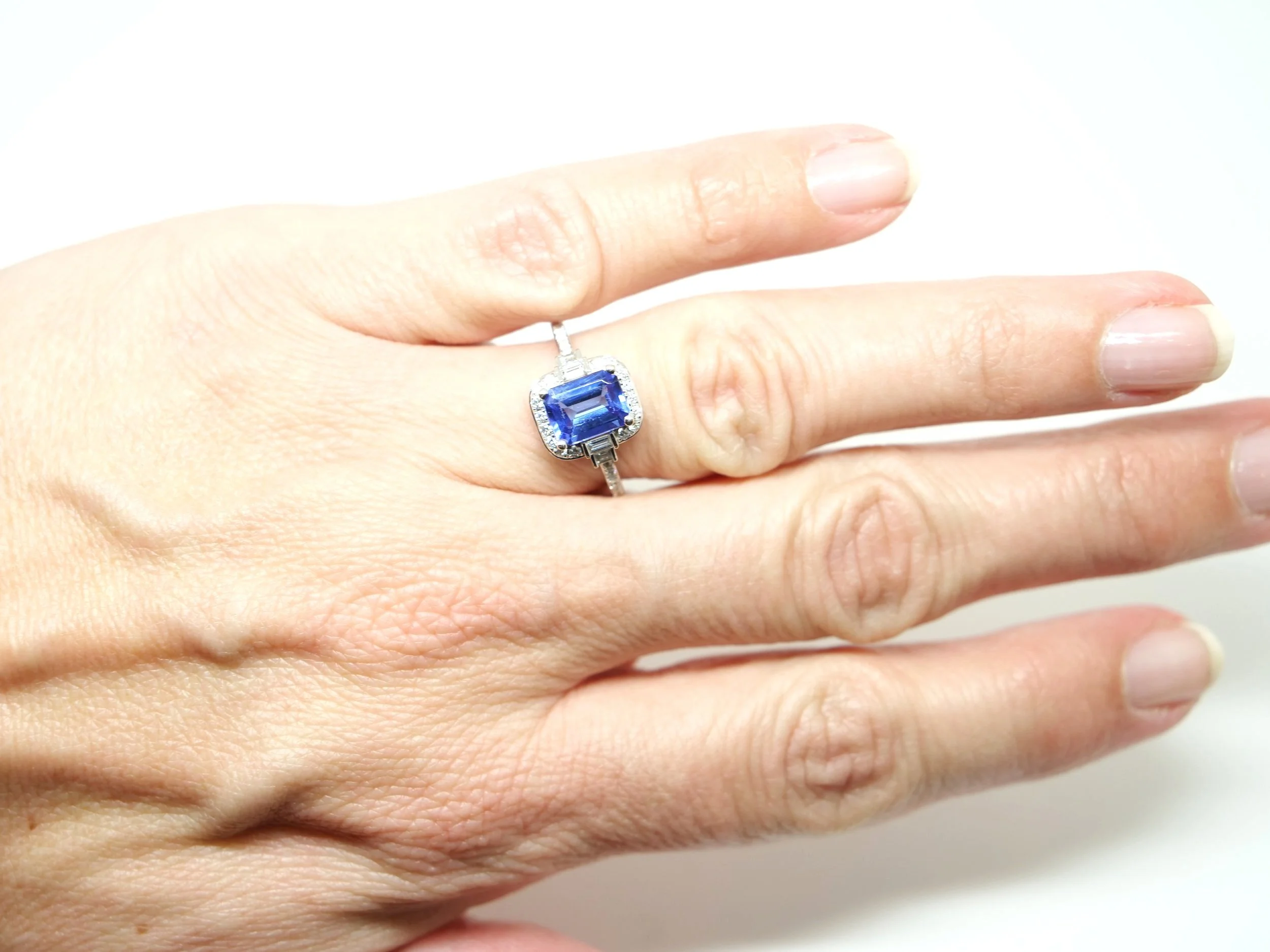Very pretty contemporary 18ct gold ring, in Art Deco style design. Set with a central emerald cut tanzanite of approximately 1.65cts, and surrounded by brilliant and baguette cut diamonds.