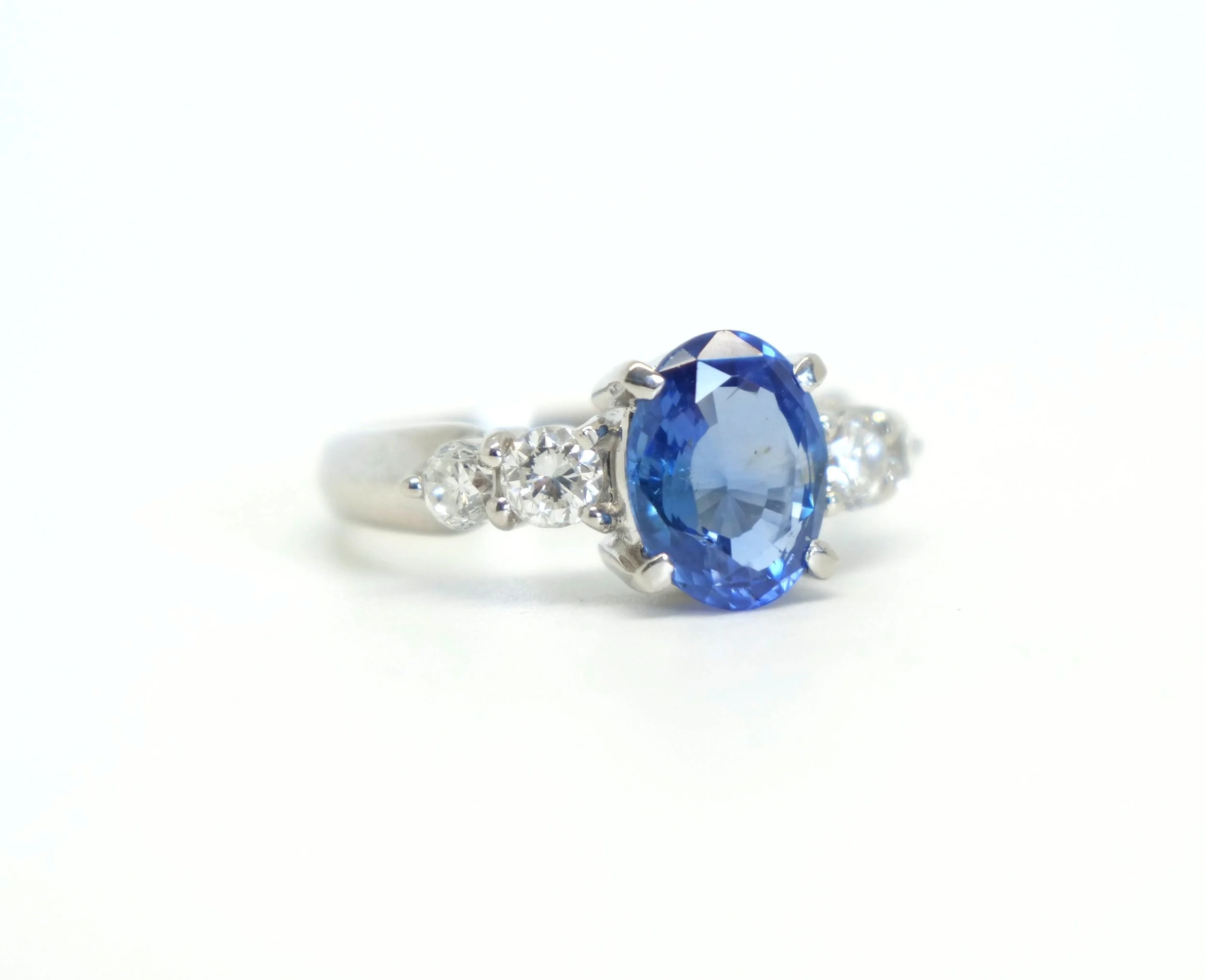 Gorgeous sapphire and diamond five stone ring, set in platinum. The central oval cut 2.2ct sapphire has two sparkly white diamonds to each side. Lovely quality.