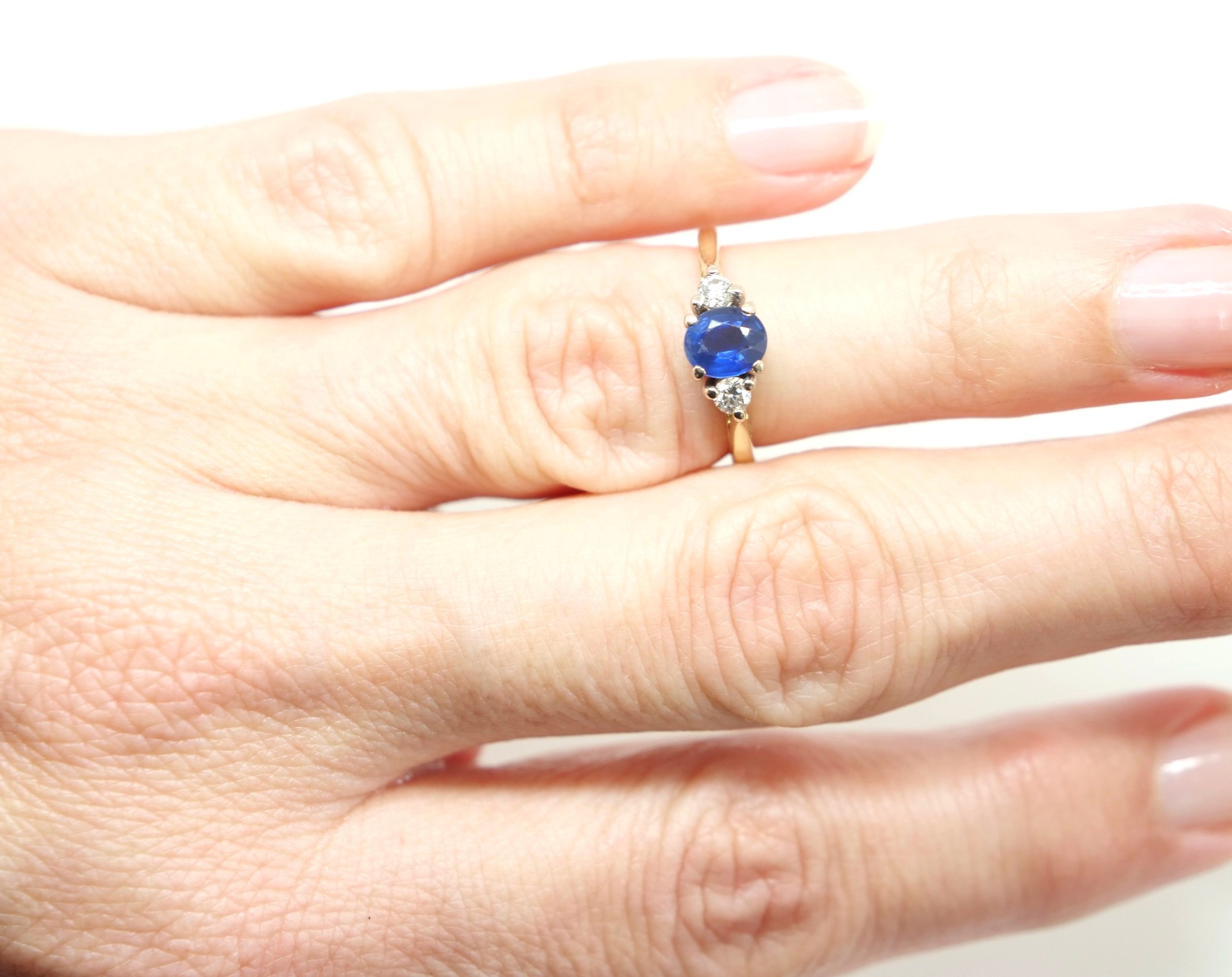 Very elegant 18ct gold vintage sapphire and diamond ring, set with a central oval cut sapphire of approximately 0.8cts. A sparkly brilliant cut diamond to each shoulder.
