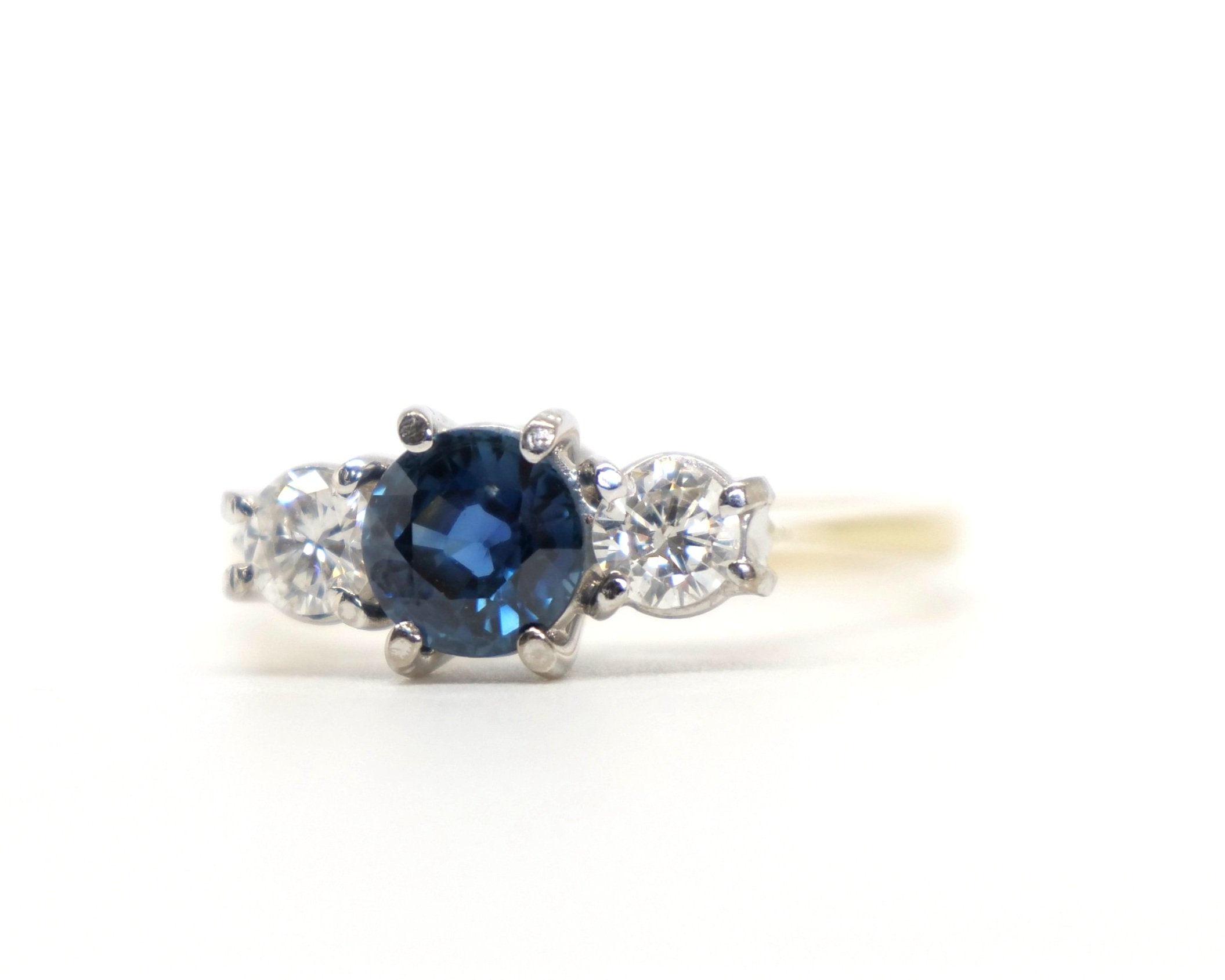 Classic 18ct gold vintage sapphire and diamond trilogy ring, set with a beautiful blue round cut central sapphire of approximately 0.7ct, with a brilliant cut diamond to each side.