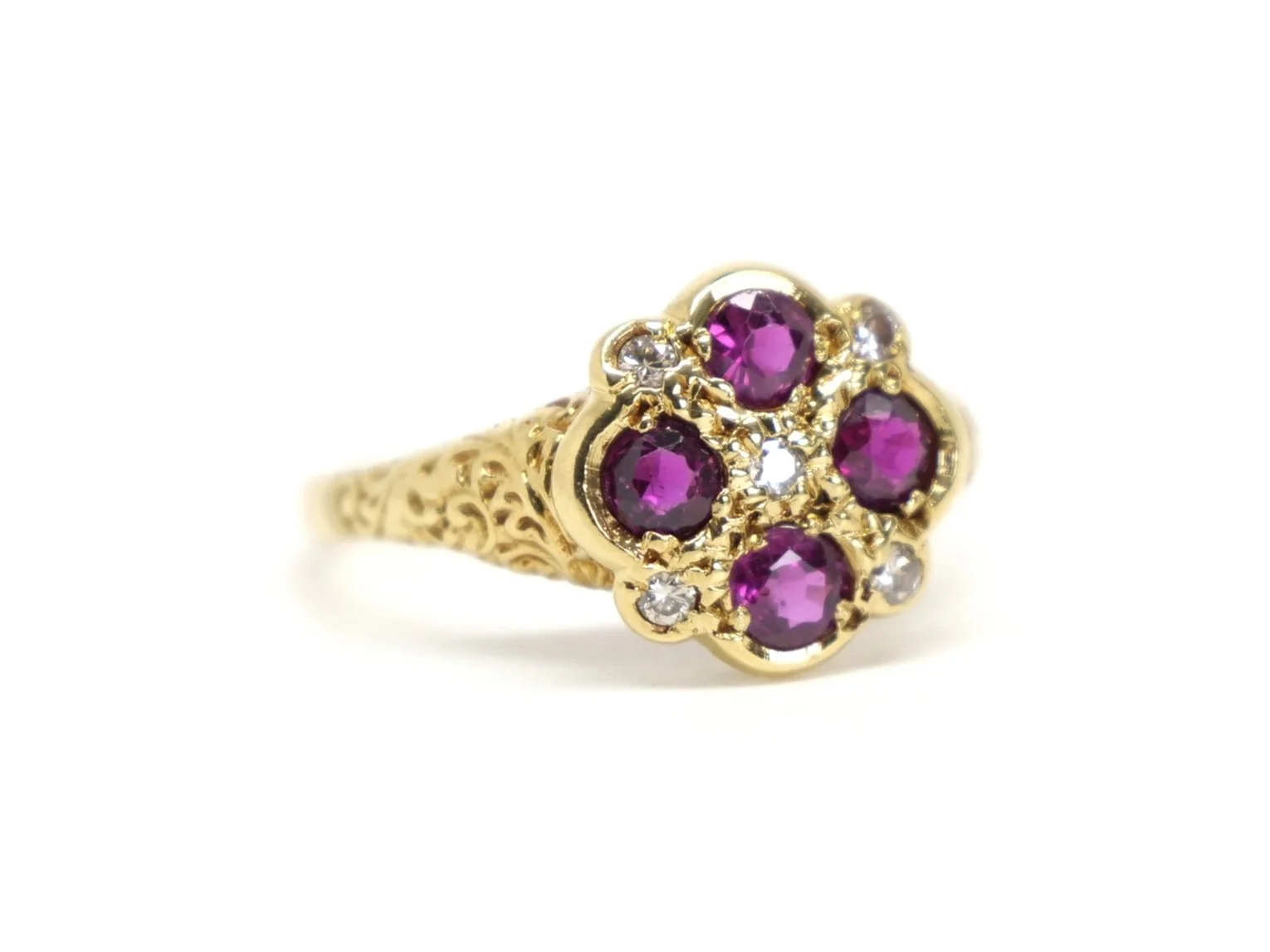 Unusual 18ct gold ring, designed in a Victorian style. Set with four rubies and five small diamonds, with intricate gold patterns to each shoulder.