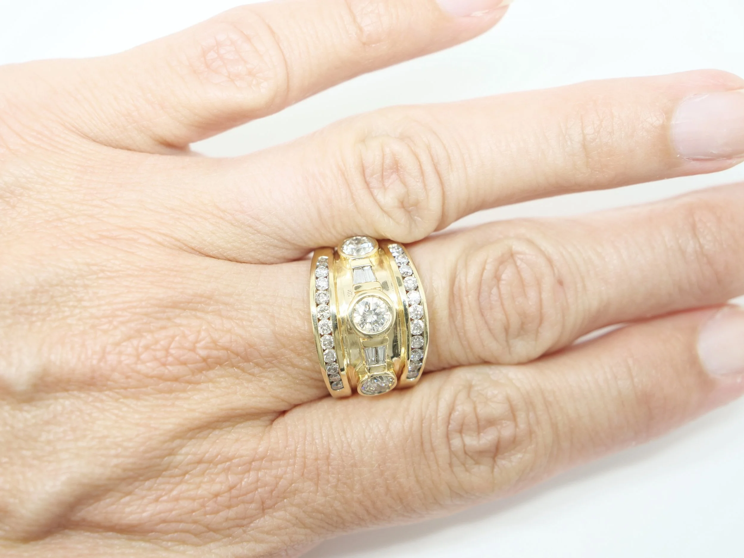 Super 14ct gold diamond statement ring, set with three central brilliant cut diamonds, baguette diamonds and brilliant cut diamonds to both top and bottom. Approximately 1.8cts of diamonds overall.