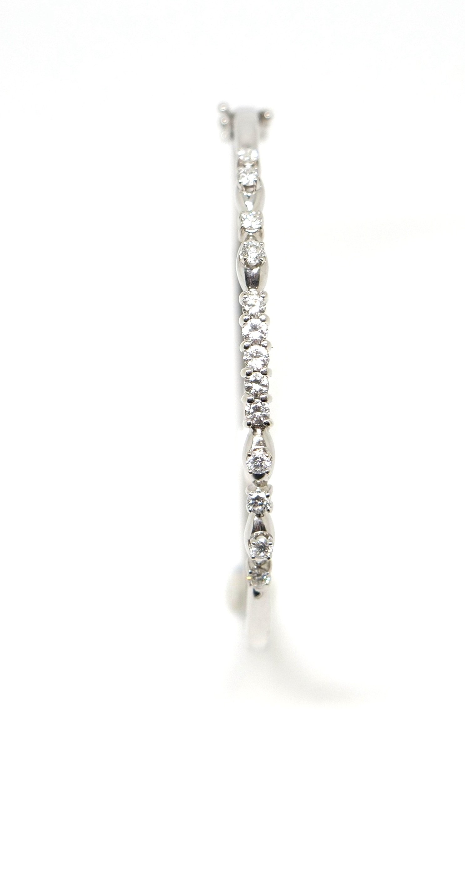 Lovely 18ct white gold bangle, set with thirteen brilliant cut diamonds, with an approximate diamond weight of 0.6cts. Double figure of eight safety clasps.