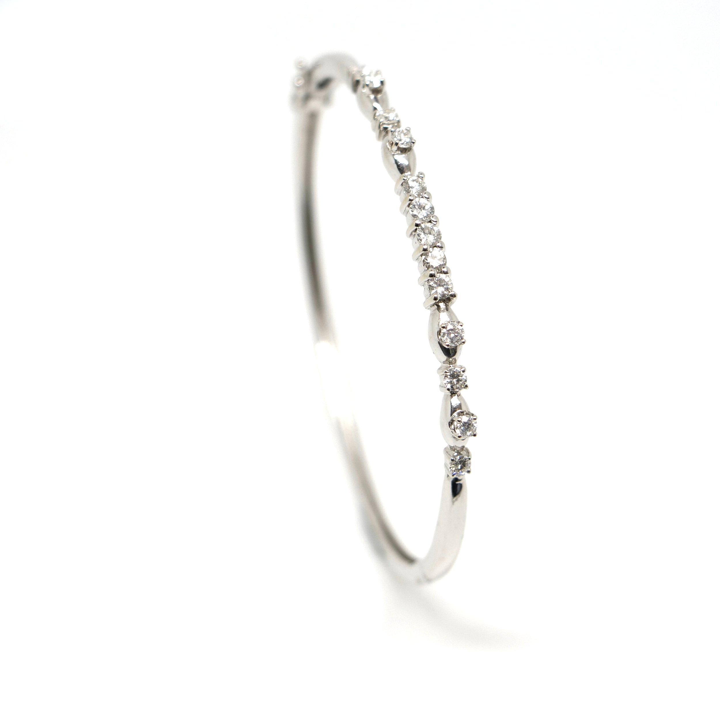 Lovely 18ct white gold bangle, set with thirteen brilliant cut diamonds, with an approximate diamond weight of 0.6cts. Double figure of eight safety clasps.