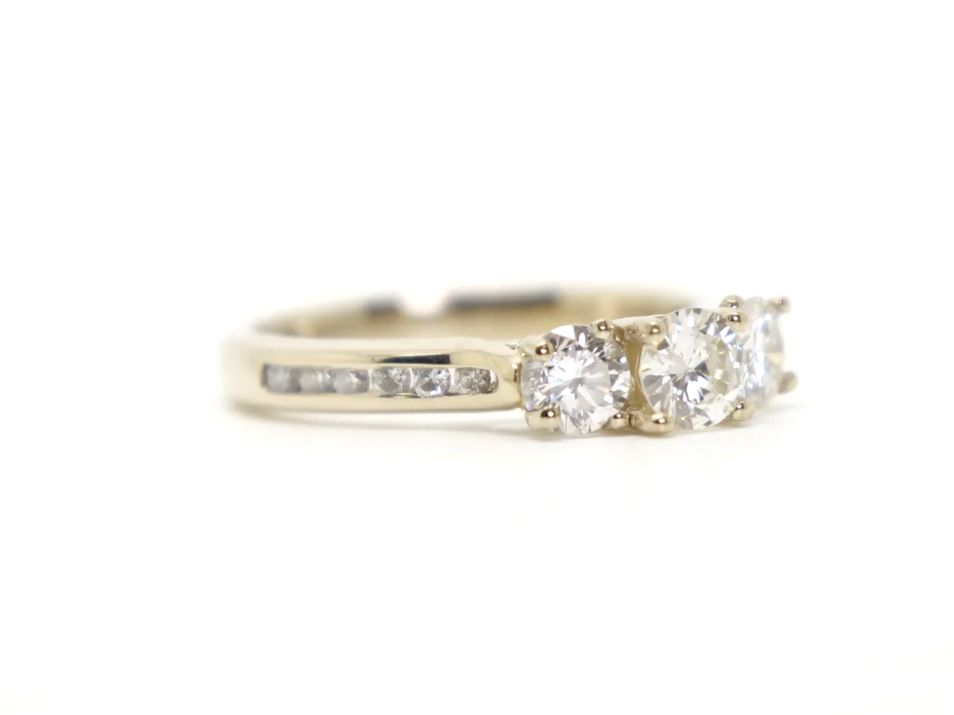 Very pretty 18ct gold diamond three stone ring, set with three brilliant cut diamonds, with further diamonds set into each shoulder. Total diamond weight approximately 1ct.