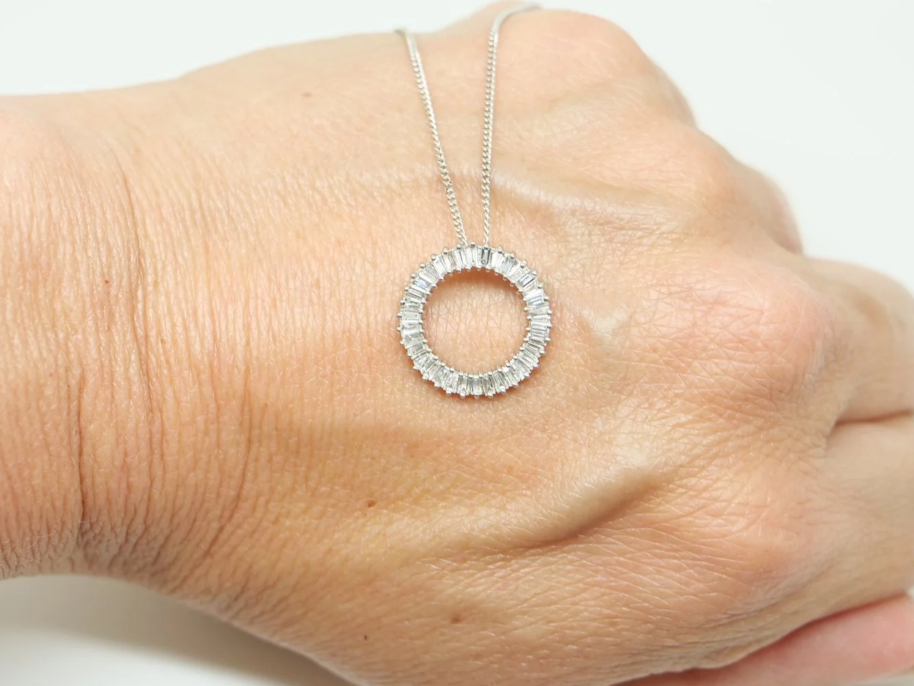 beautiful platinum diamond circle pendant set with baguette cut diamonds