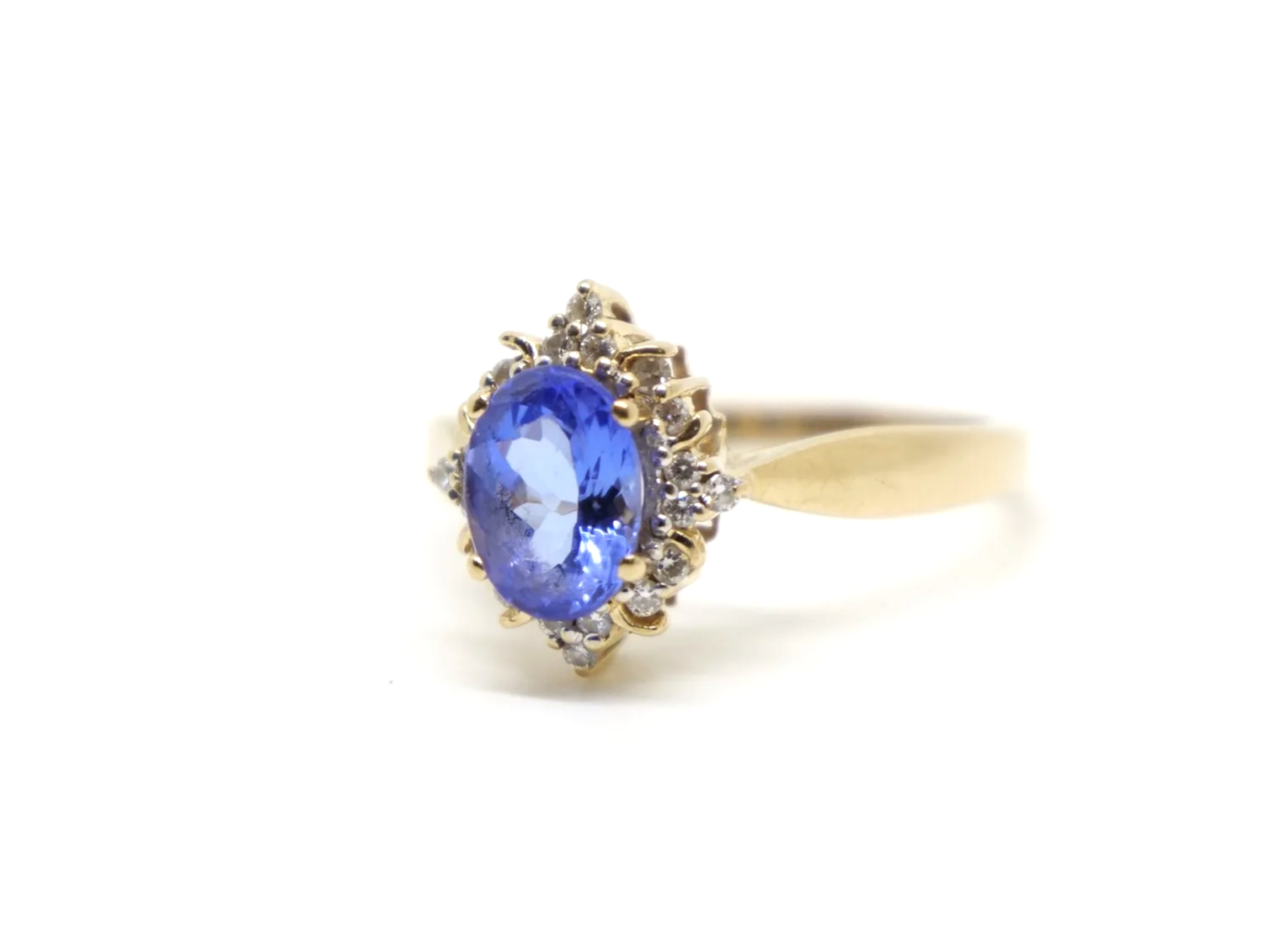 Very pretty 18ct gold tanzanite and diamond cocktail ring, set with a vibrant oval cut tanzanite and surrounded by brilliant cut diamonds.