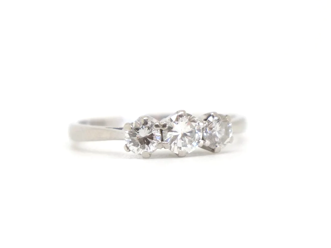 Classic platinum and diamond three stone ring, set with a larger central diamond, with a smaller diamond to each side. Approximately 0.85ct total diamonds.