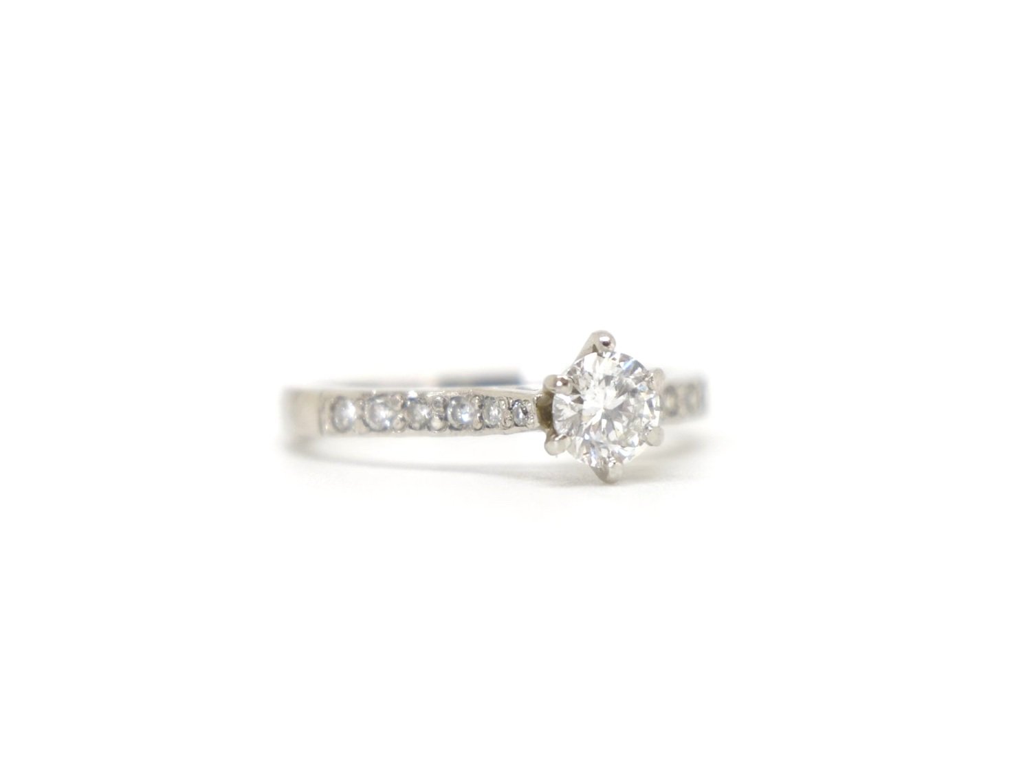 Super platinum gold diamond solitaire ring, set with a central brilliant cut diamond of approximately 0.55cts, with further brilliant cut diamonds set into each shoulder.