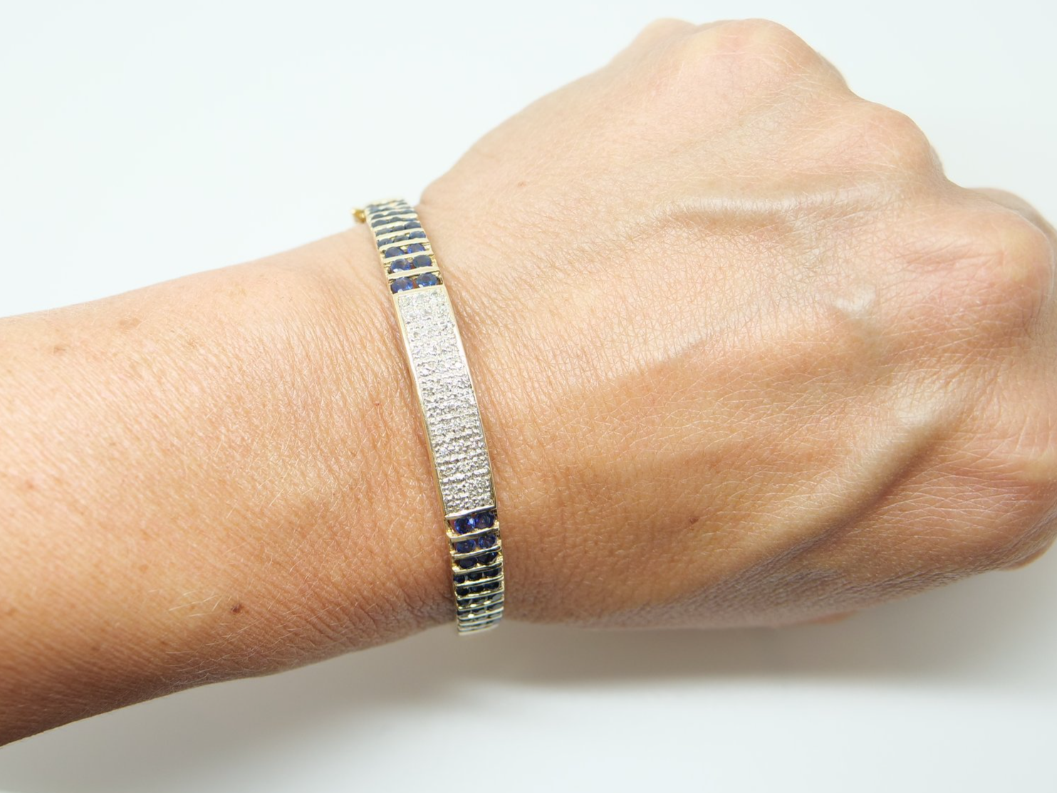Unusual vintage 9ct gold sapphire and diamond bangle, set with a pave design central panel set with diamonds, with channel set sapphires to each side.