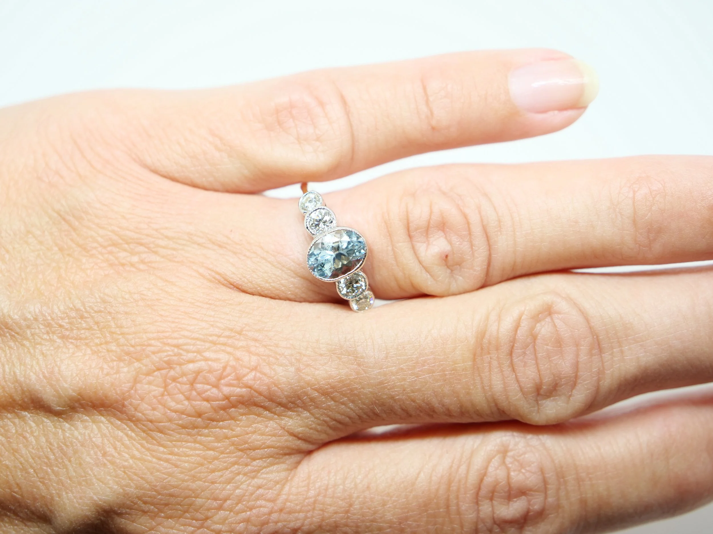 Super 18ct gold and platinum aquamarine and diamond five stone ring, set with an oval cut bezel aquamarine, with two brilliant cut diamonds to each side.
