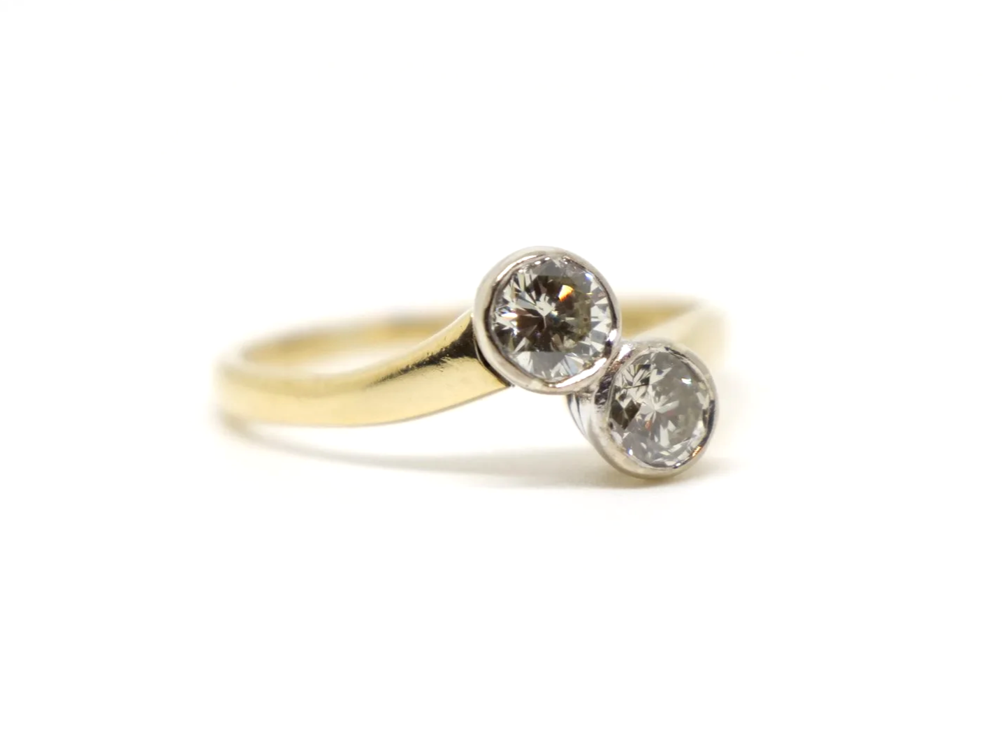 A vintage take on an old Art Deco design, this lovely quality 18ct gold ring is set with two brilliant cut diamonds in this more contemporary toi et moi.