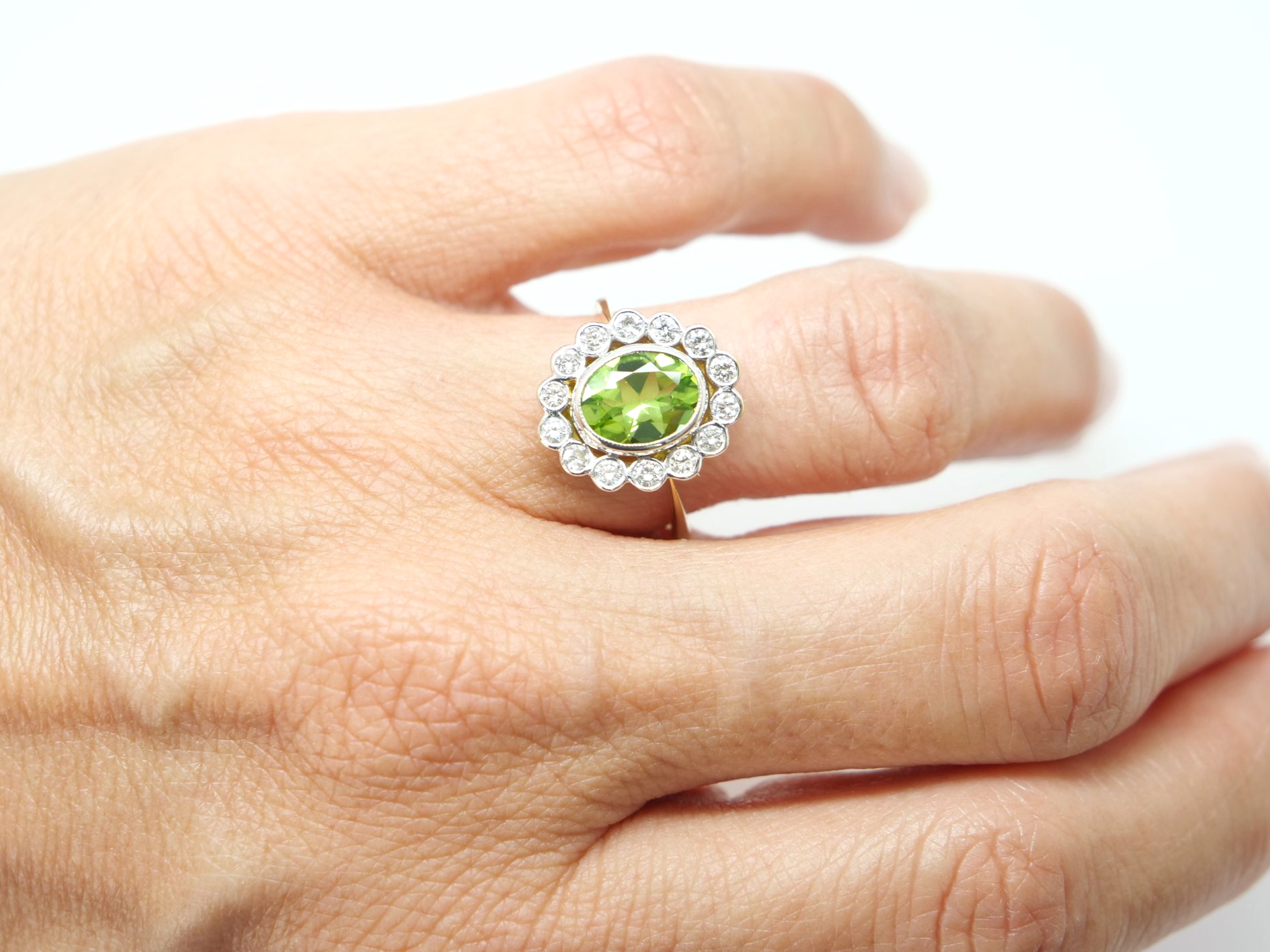 Superb vintage 18ct gold peridot and diamond ring, set with a 1.6ct oval cut peridot and surrounded by approximately 0.55cts of brilliant cut diamonds.