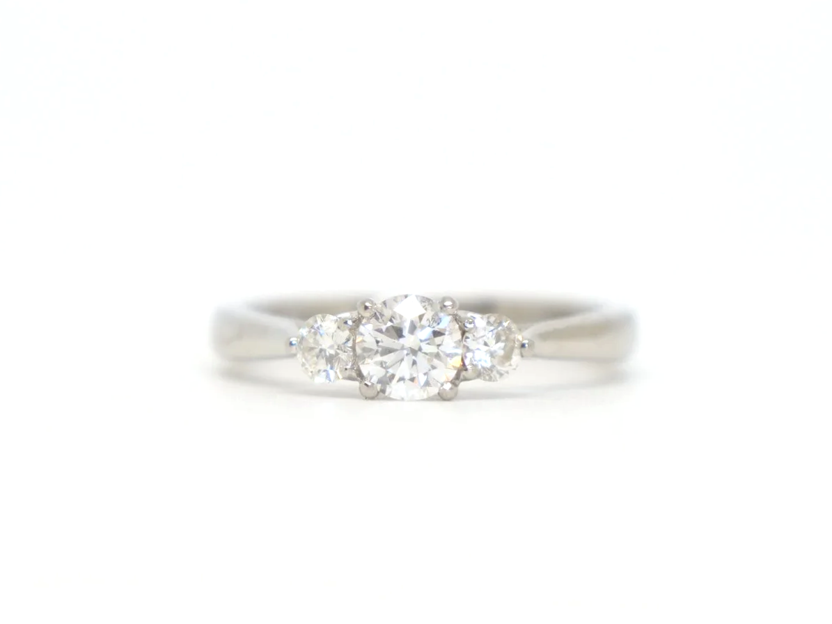 Platinum three stone diamond ring, central diamond flanked by two round diamonds