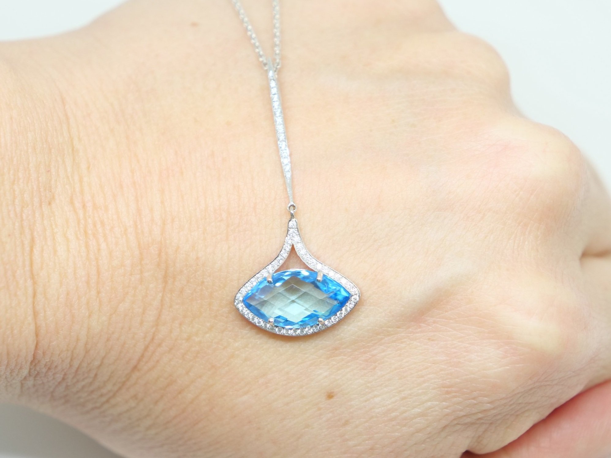 Very unusual designer style contemporary 18ct gold necklace, set with a large marquise cut blue sapphire, with diamonds both around the main gemstone and along the bale.