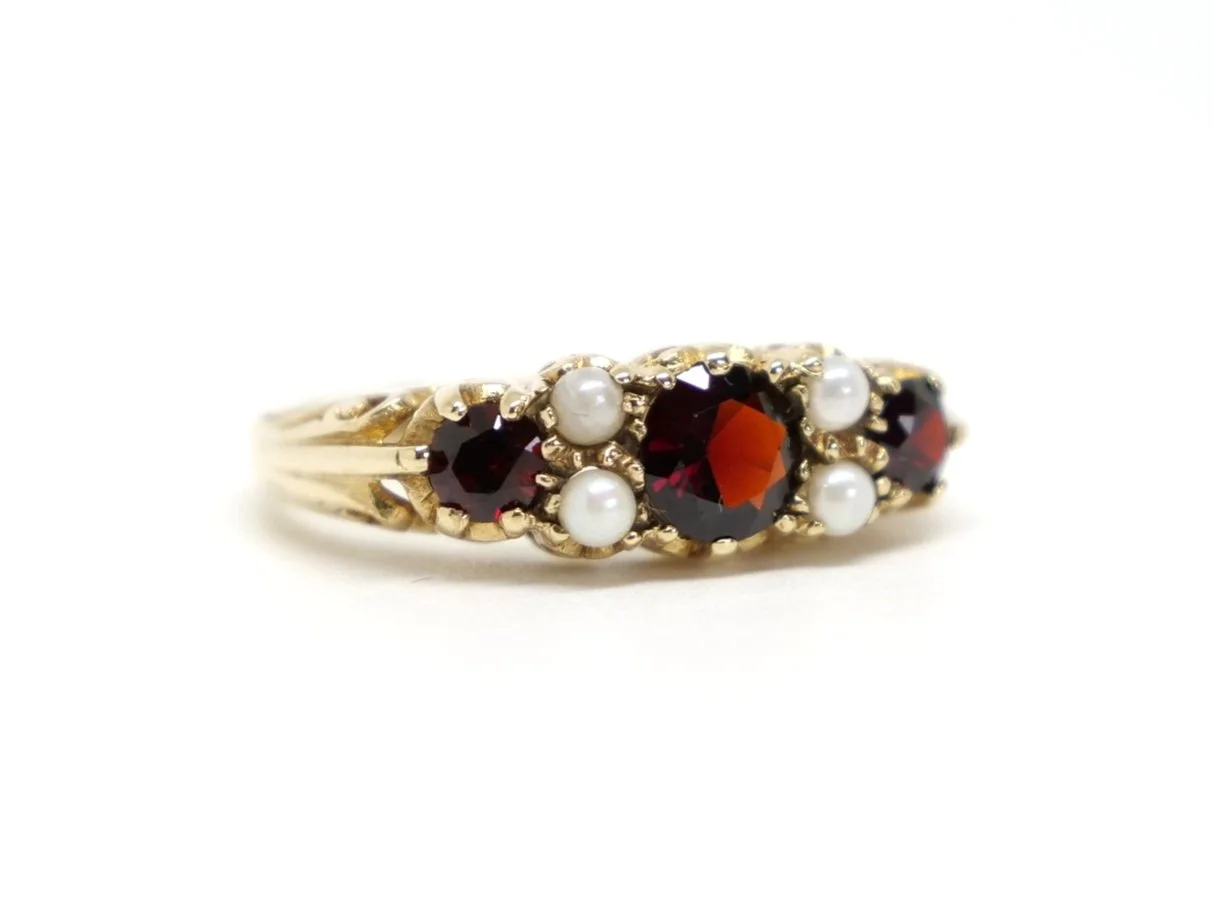 Vintage 9ct gold garnet and pearl ring, set with three round cut garnets and four seed pearls in this lovely traditional design.