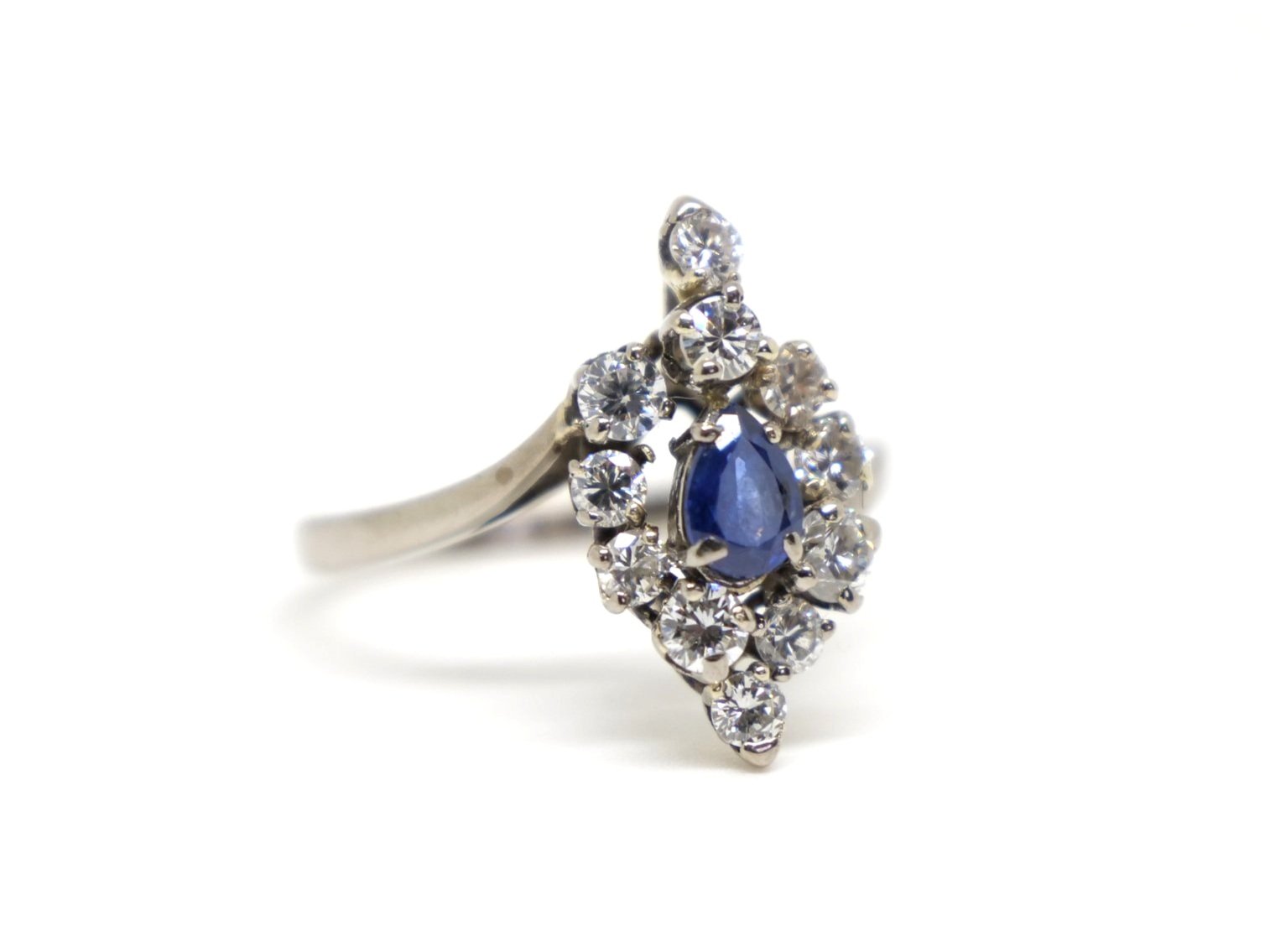 Unusual vintage 18ct gold sapphire and diamond cocktail ring, set with a central pear cut sapphire and surrounded by brilliant cut diamonds of different sizes.