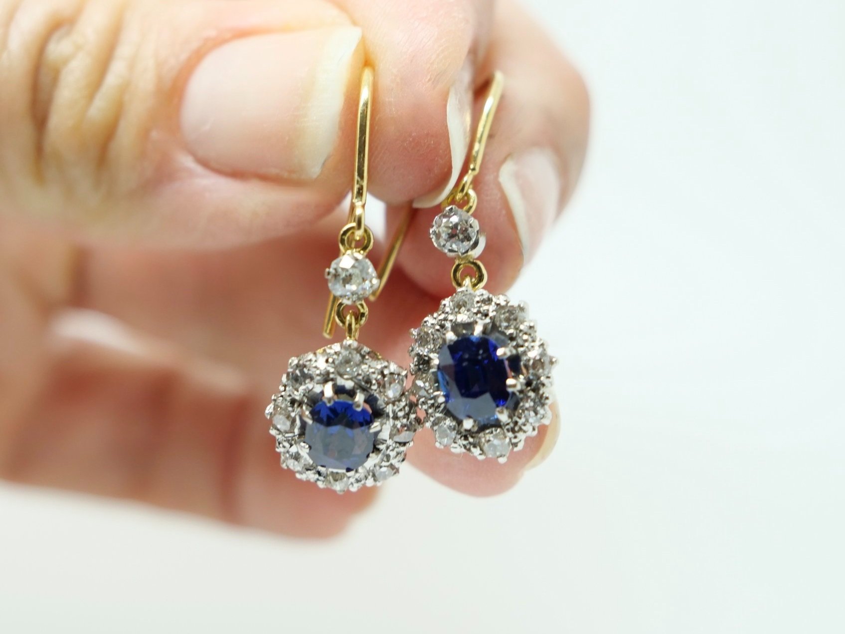 Superb quality vintage drop earrings in 18ct gold, each set with a beautiful oval cut blue sapphire and surrounded by old cut diamonds.