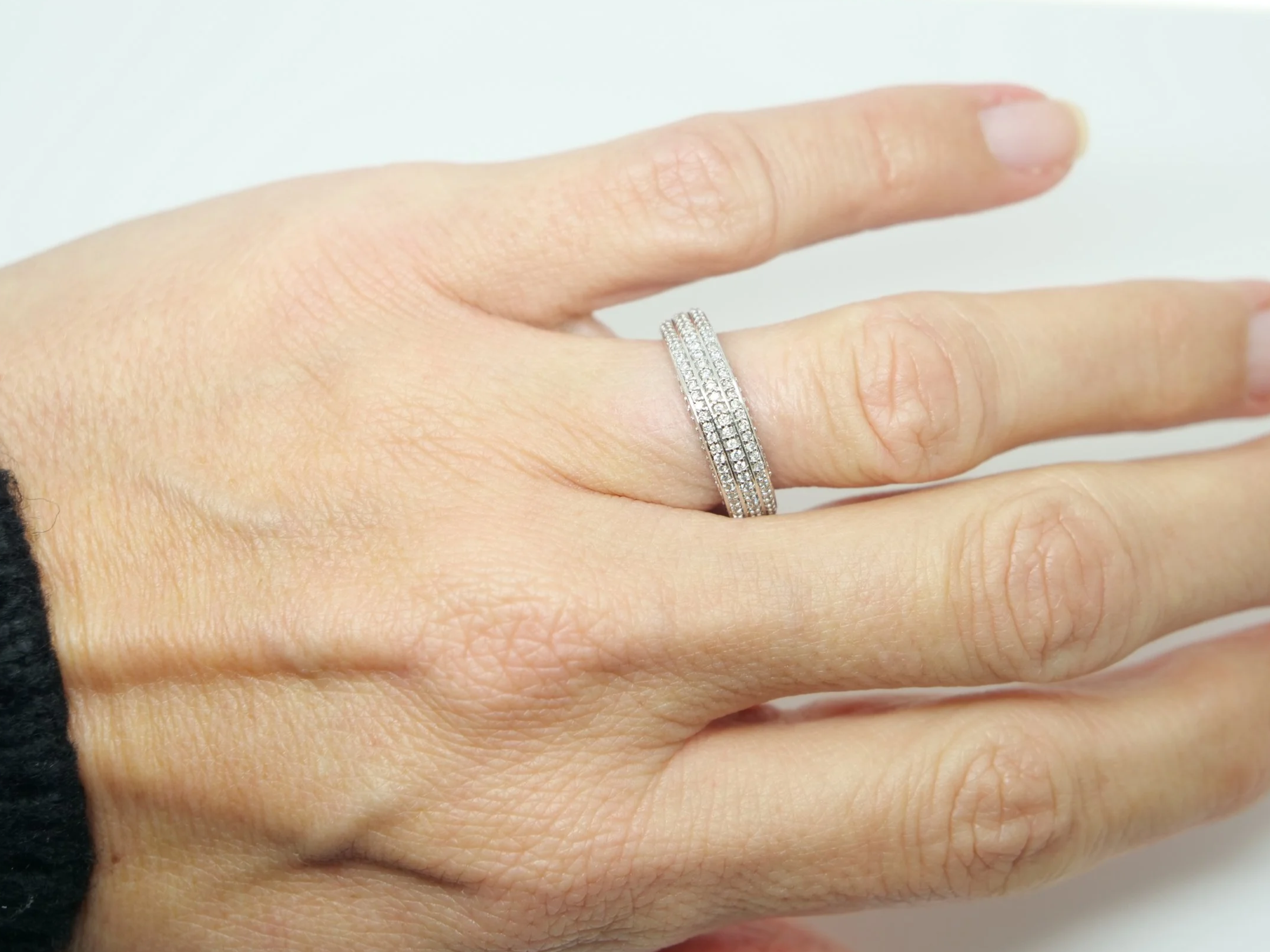 Contemporary 18ct gold triple row diamond three quarter eternity ring, with three rows of diamonds and further diamonds in both top and bottom of setting.