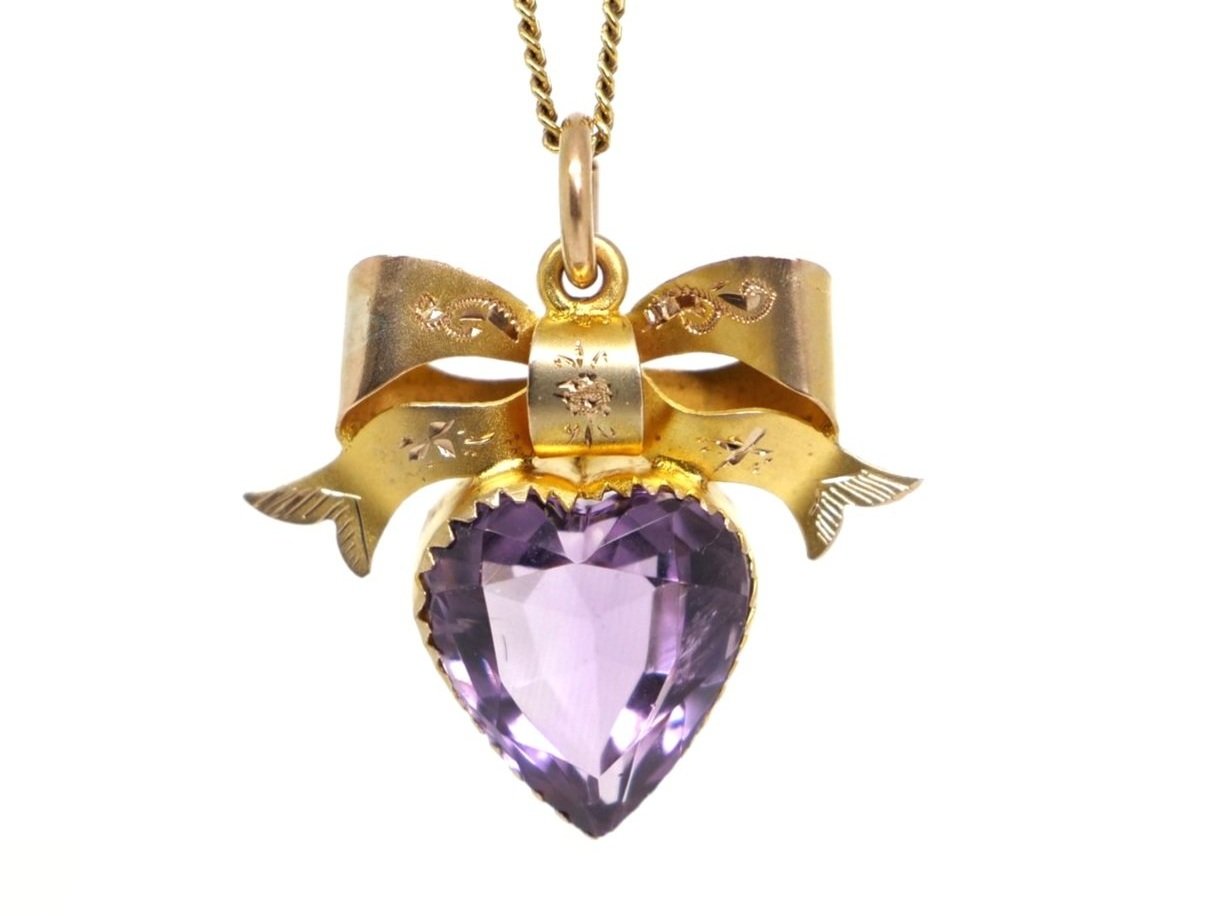 Beautiful 9ct gold turn of the century amethyst pendant, cut into a heart design. Lovely bow with etched designs above the amethyst heart. With (later) 9ct chain.