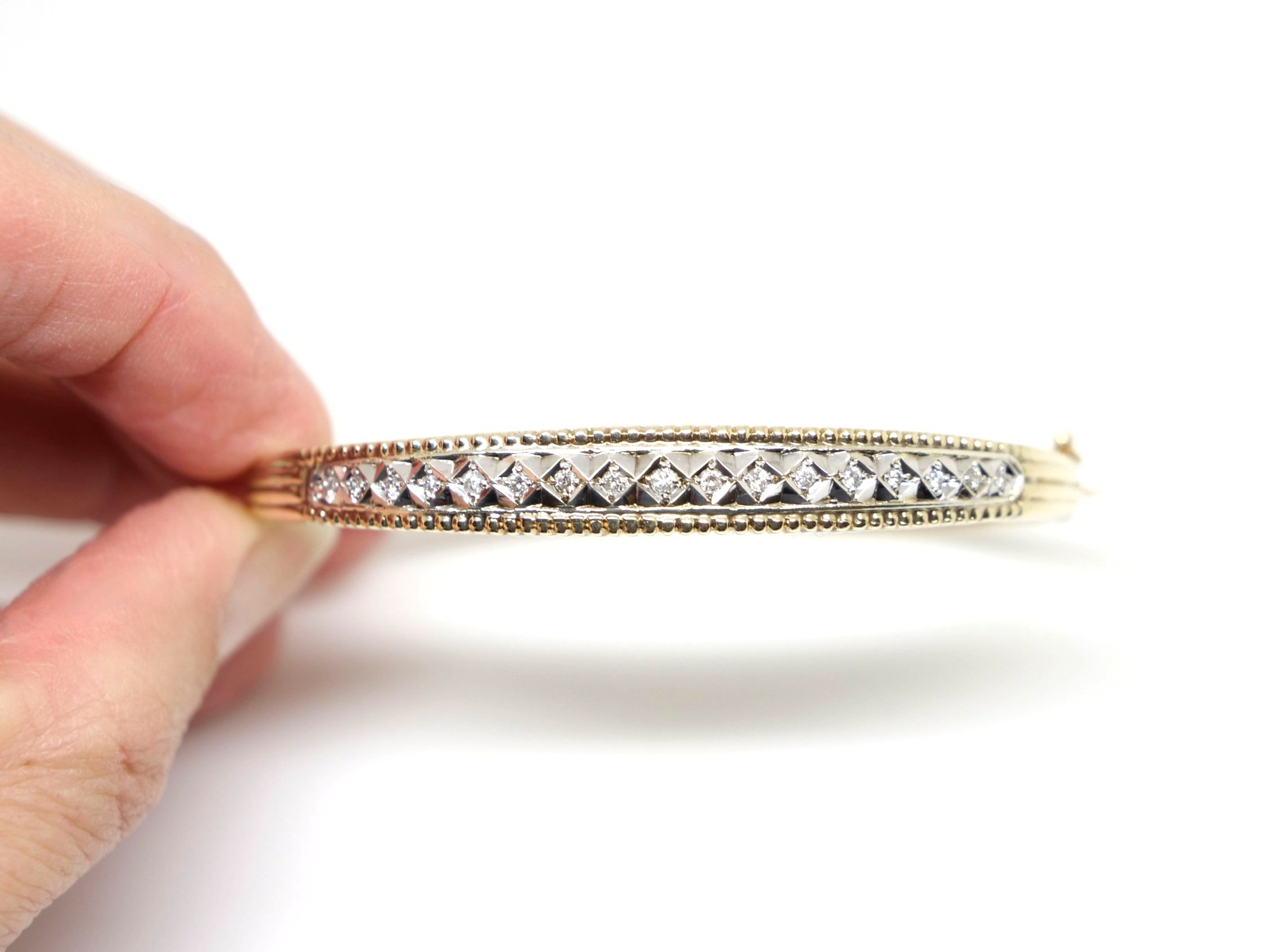 Lovely vintage heavy 9ct gold diamond bangle, set with seventeen small diamonds in this lovely diamond cut design. With figure of 8 safety catch.