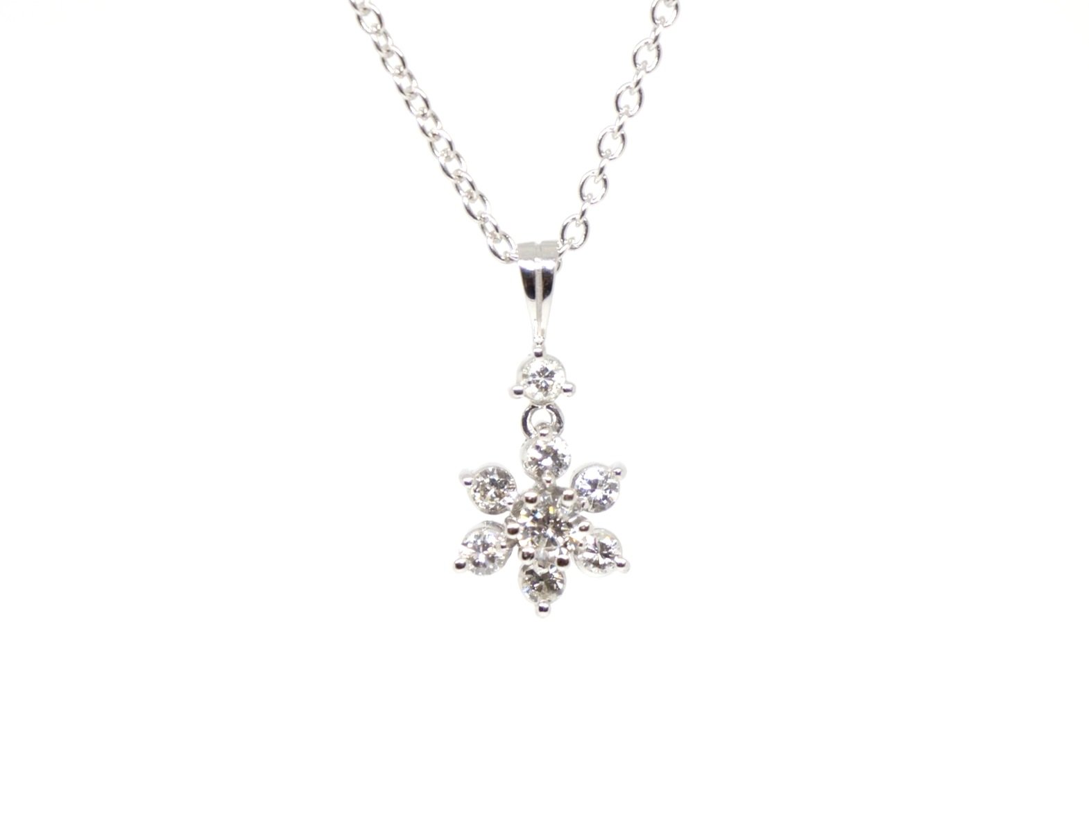 Very elegant 9ct gold diamond flower pendant and chain, set with a small drop diamond and then a lovely diamond flower. Approximately 0.5ct diamonds total.