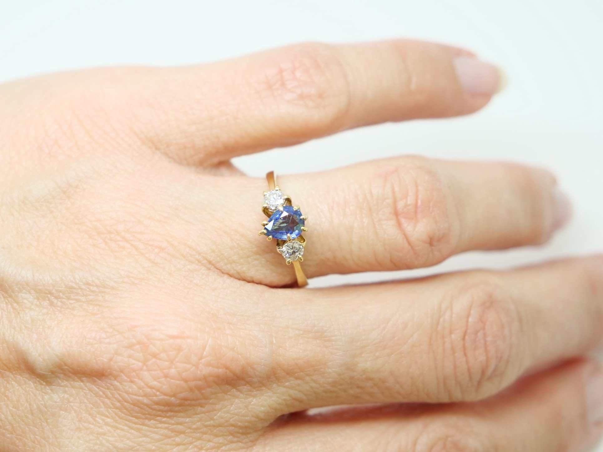 Beautiful vintage 18ct gold sapphire and diamond three stone ring, set with a pear cut sapphire and with a brilliant cut diamond to each side.