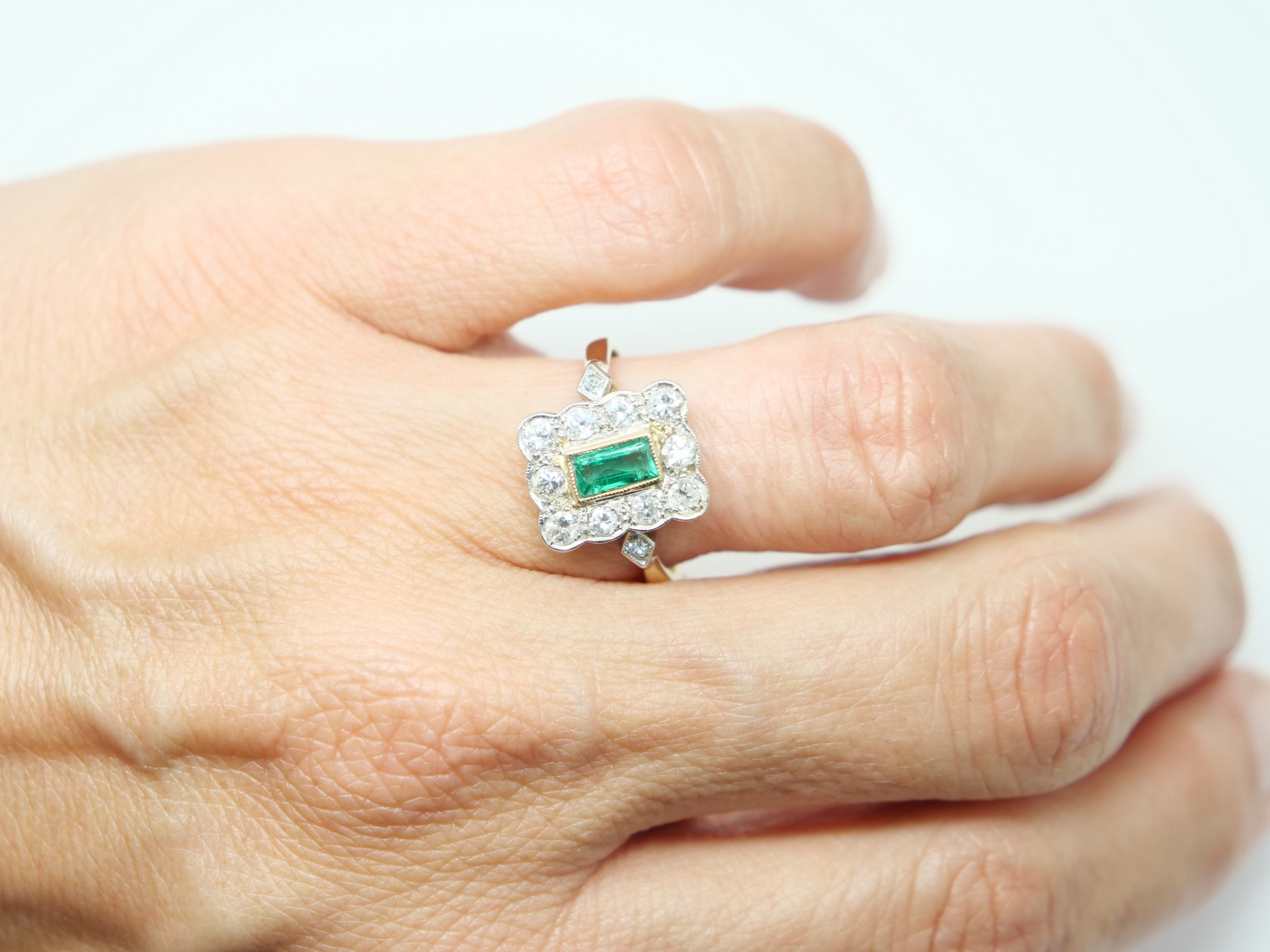 Very pretty vintage 18ct gold emerald and diamond ring, set with an emerald cut emerald and surrounded by diamonds.