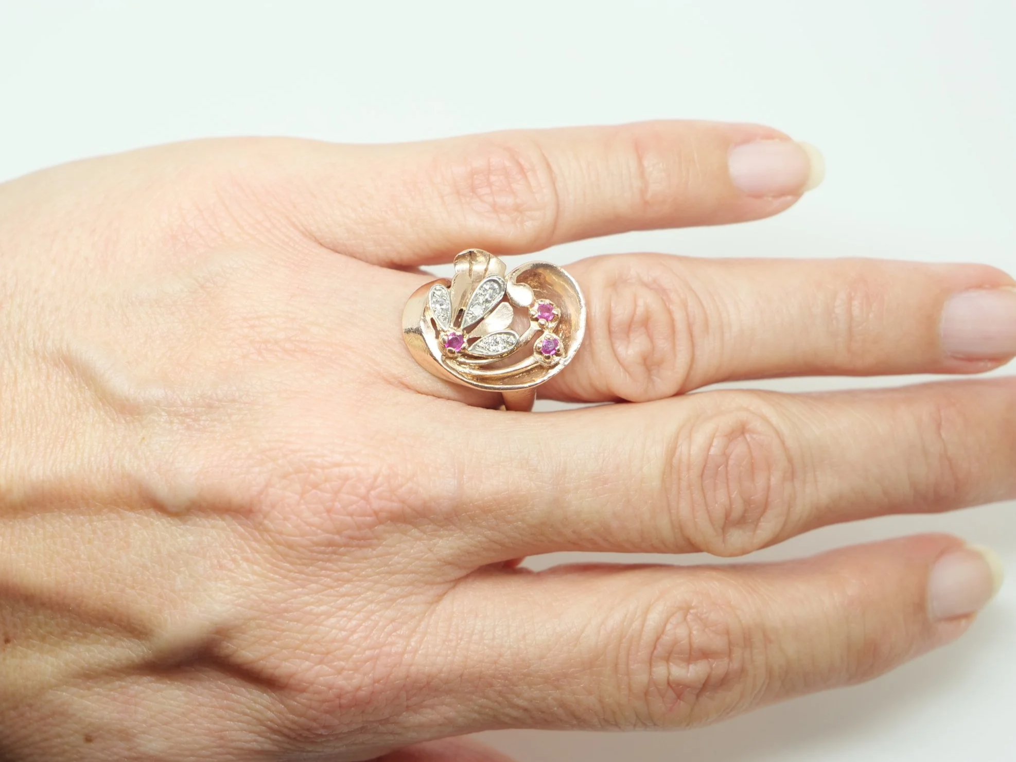 Very unusual 14ct rose gold Art Deco ring, in a large swirl style design. Each of the flower elements of the ring are set with round cut rubies, with diamonds set into each petal.