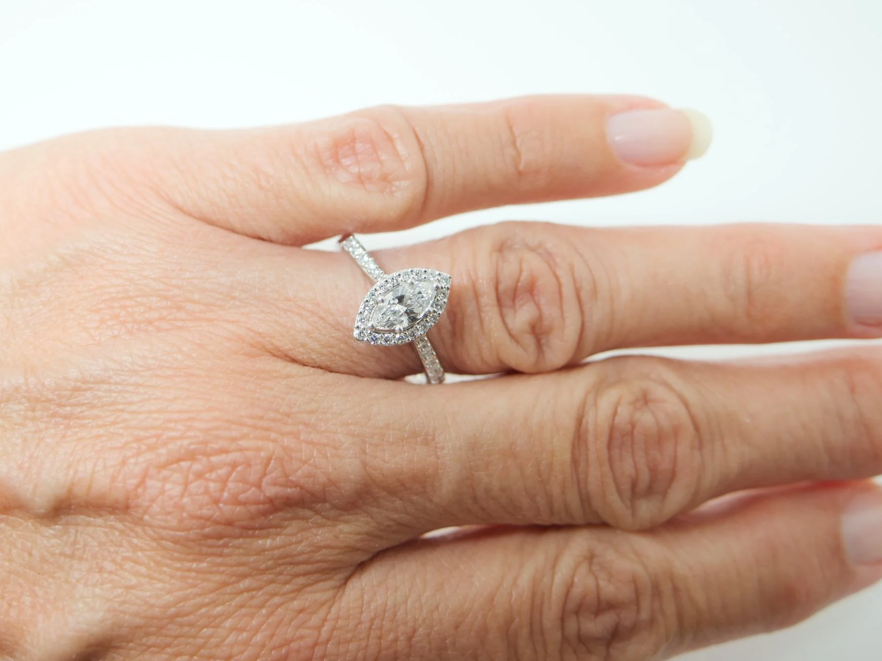 platinum diamond halo ring set with a marquise-cut diamond at the centre, surrounded by a pavé-set halo