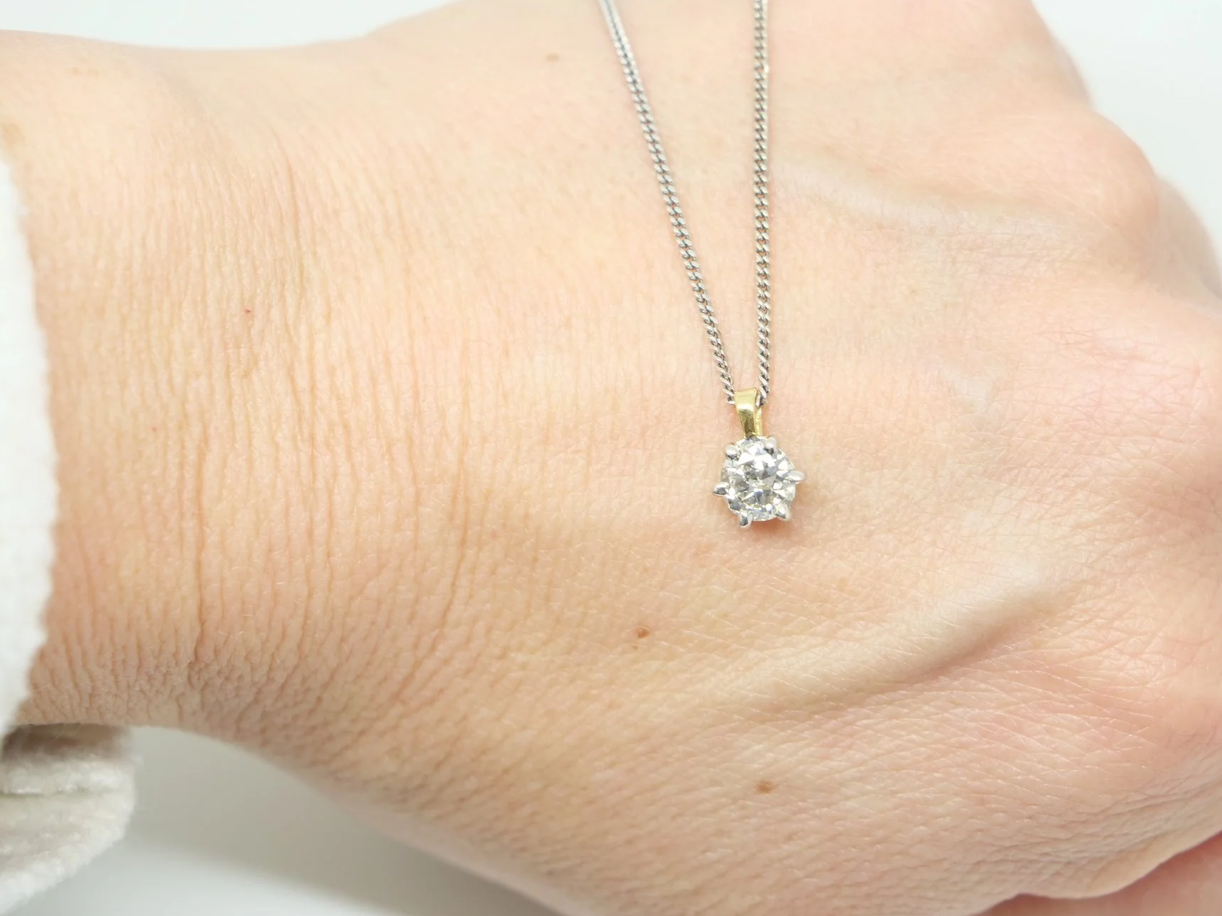 Classic 18ct gold diamond solitaire pendant, set with a very sparkly brilliant cut diamond. Diamond set in white gold with yellow gold bale.