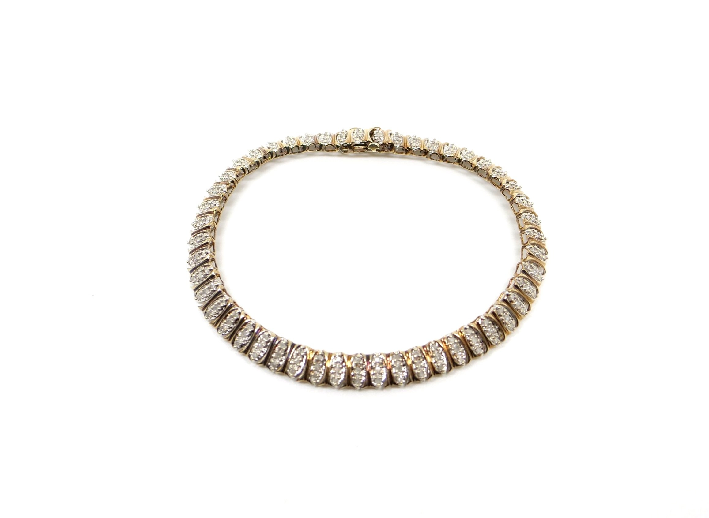 Lovely vintage diamond tennis bracelet, set with three small diamonds in each link. Total of approximately 1ct diamond weight.