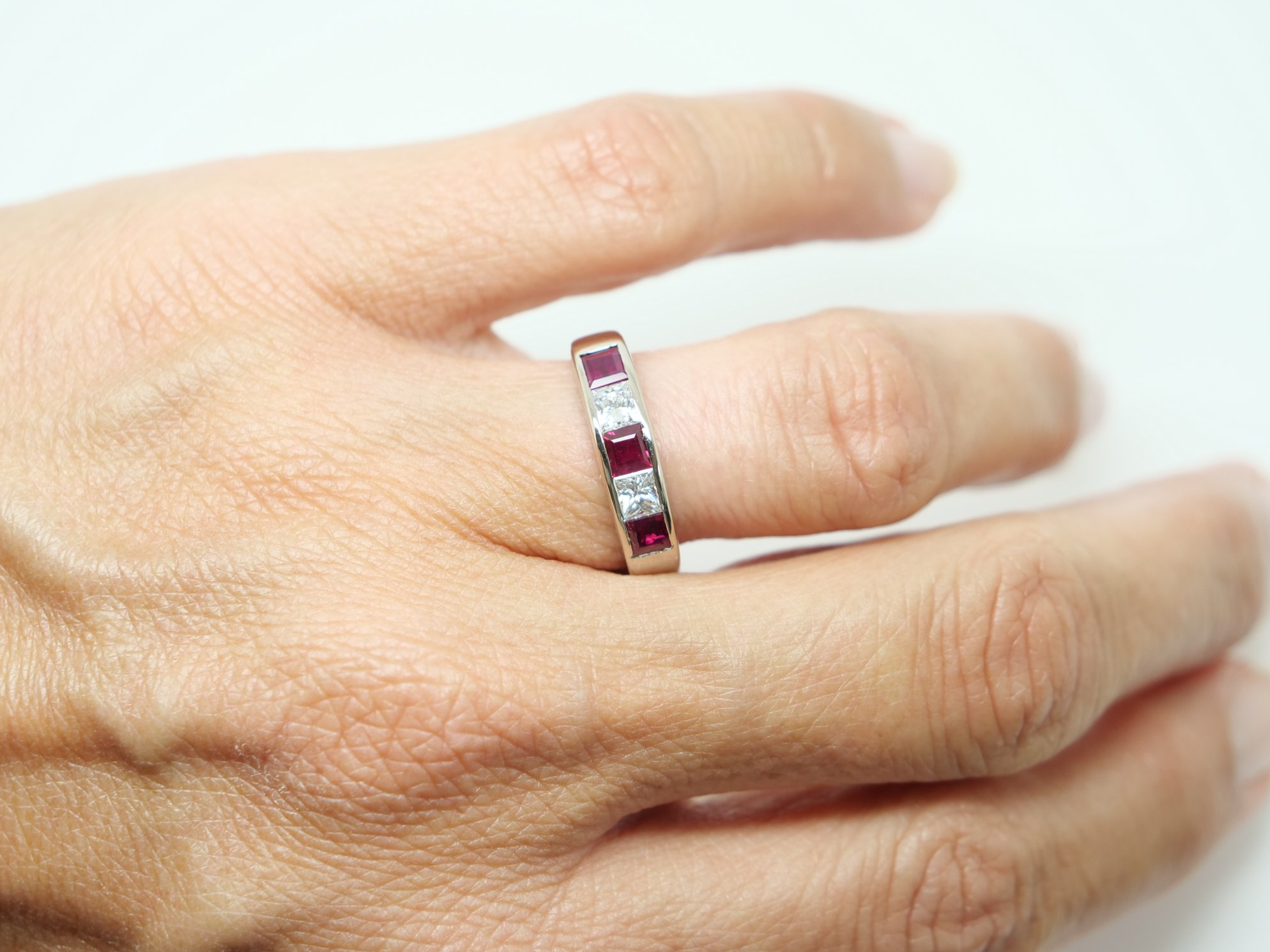 Bespoke 18ct gold ruby and diamond half eternity style ring, set with step cut rubies and princess cut diamonds.