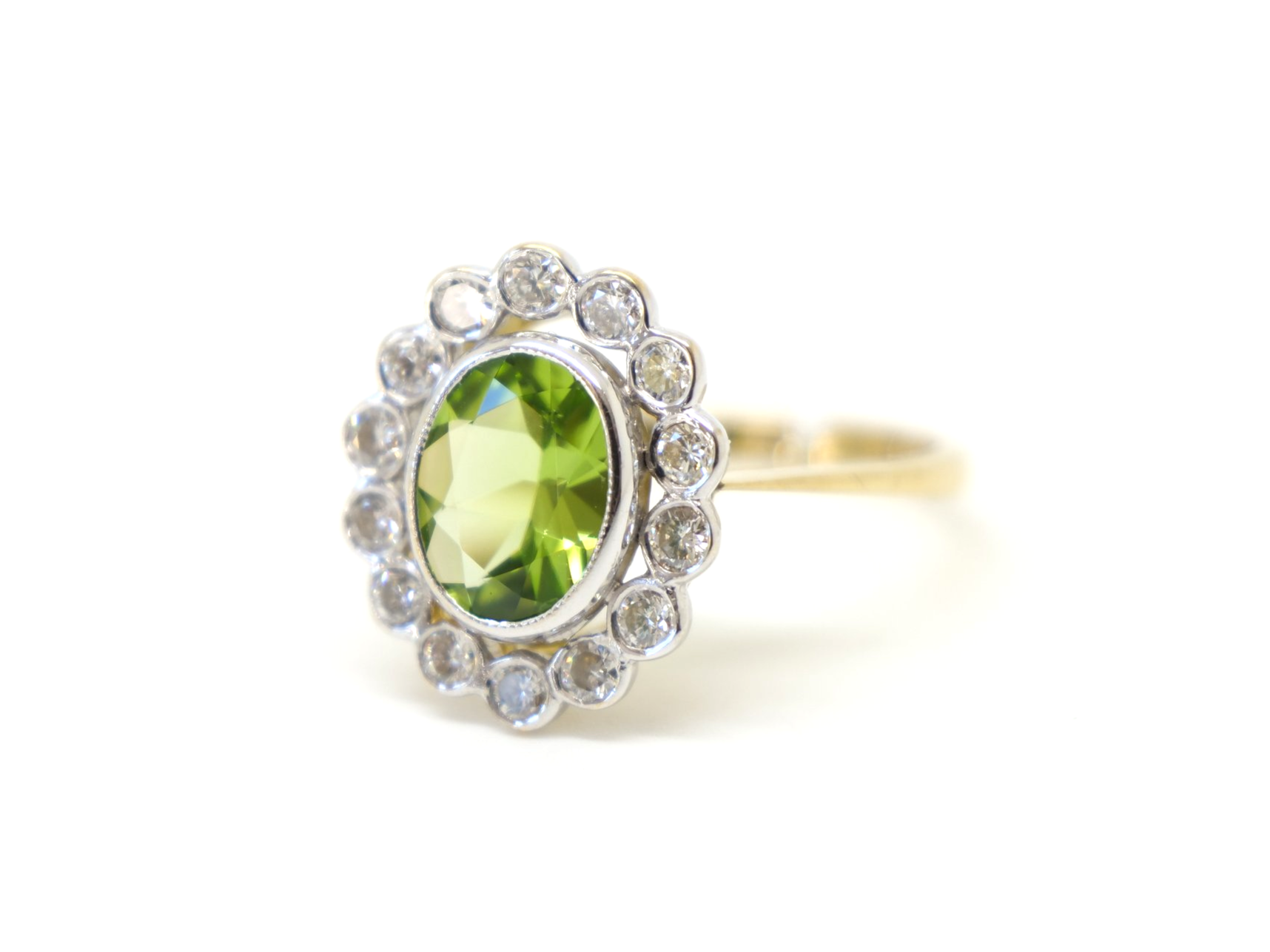 Superb vintage 18ct gold peridot and diamond ring, set with a 1.6ct oval cut peridot and surrounded by approximately 0.55cts of brilliant cut diamonds.