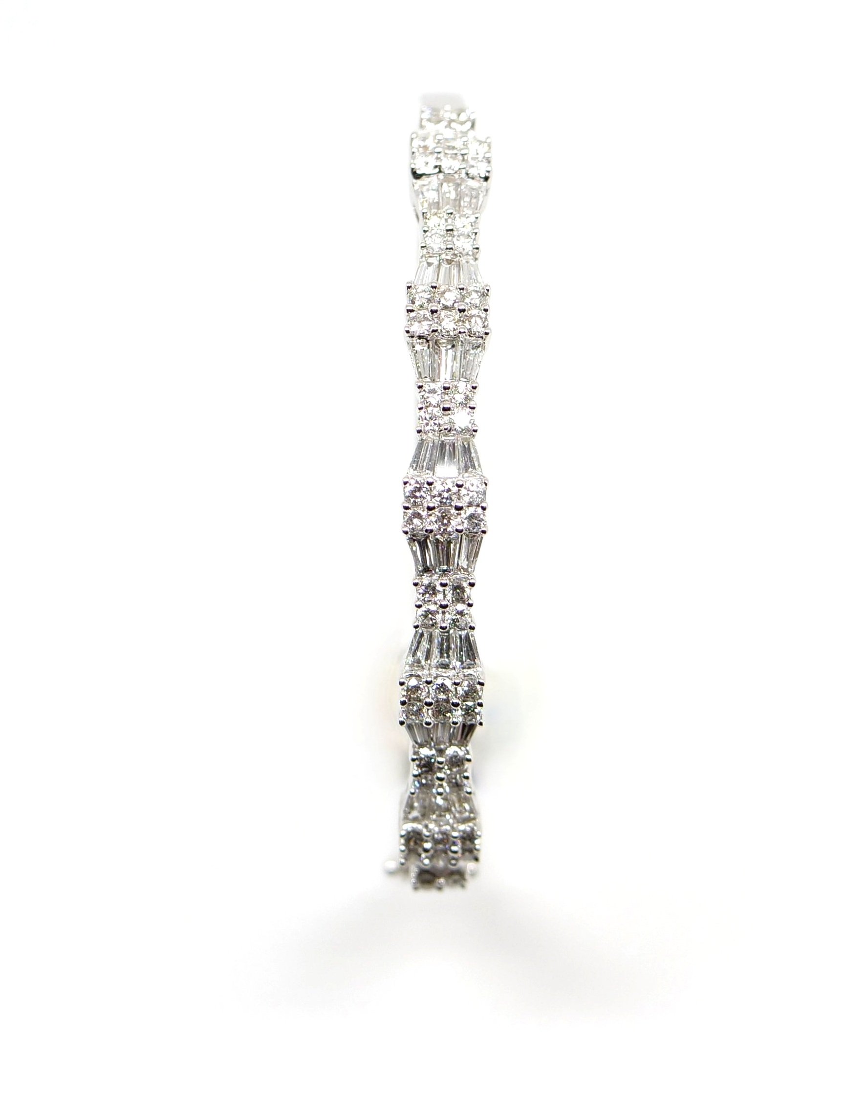 Show stopping contemporary 14ct white gold bangle, set with approximately 2.5cts of brilliant cut and baguette cut diamonds in this fabulous geometric design.
