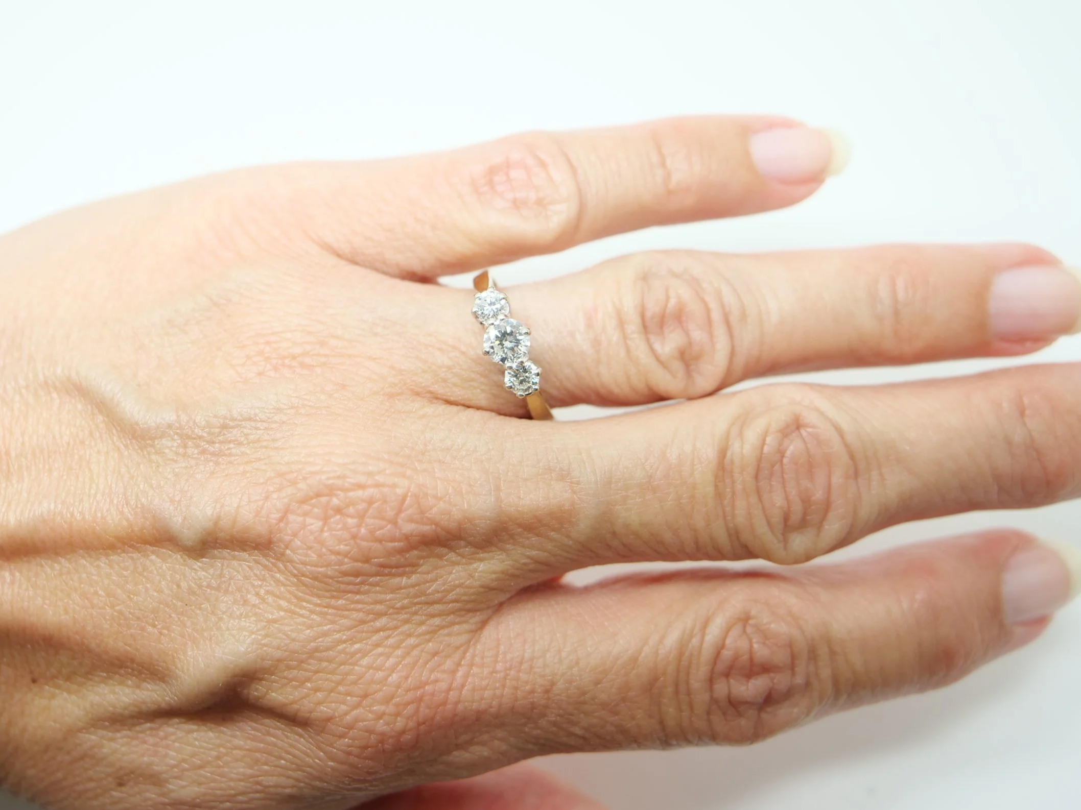 A classic 18ct gold diamond three stone ring from 1997, set with three round brilliant cut diamonds of approximately 1 carat in total.