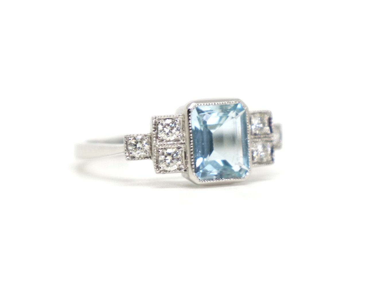 Beautiful Art Deco style platinum aquamarine and diamond ring, set with a central emerald cut aquamarine, with three diamonds set in a step design to each shoulder.