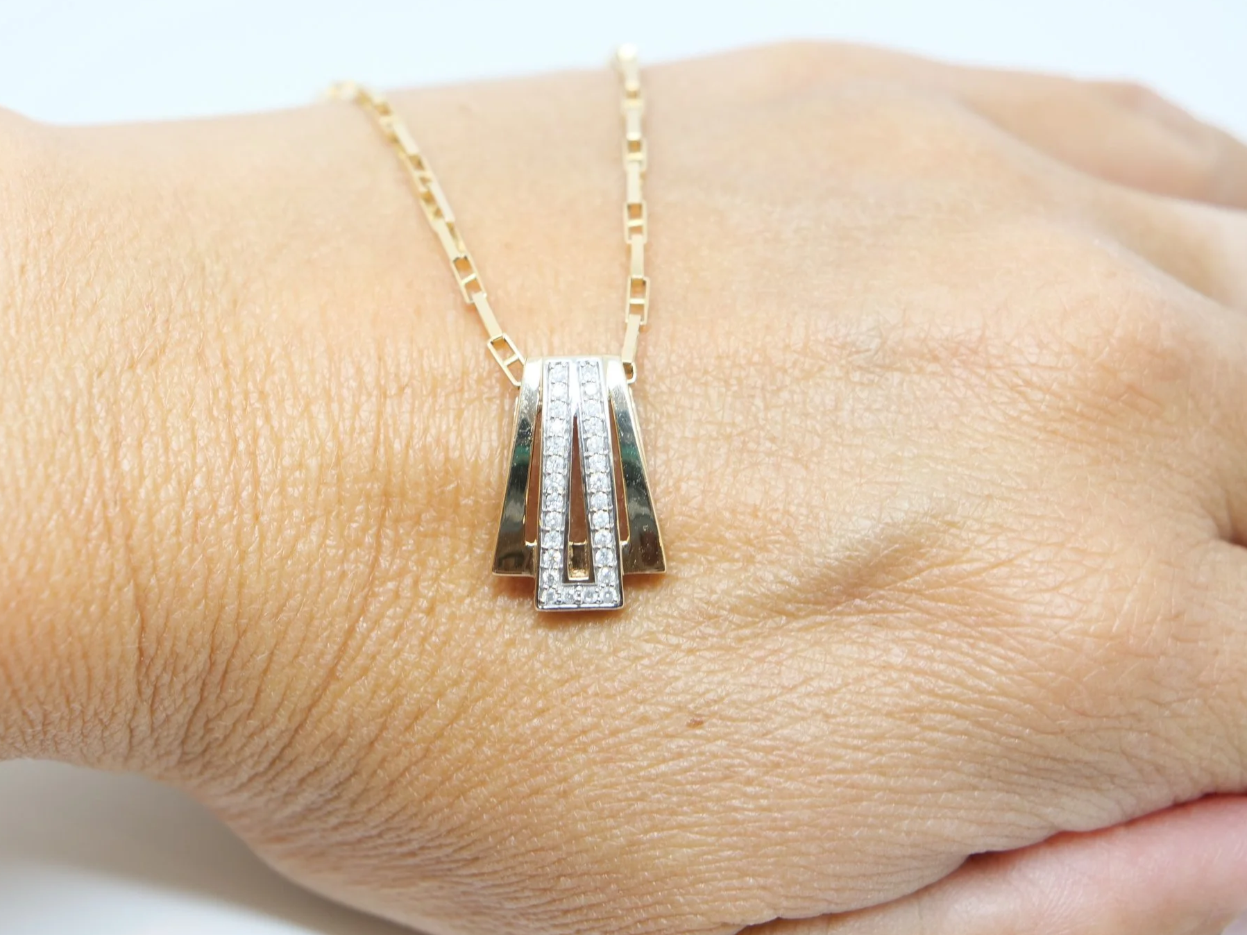 9ct gold diamond pendant necklace with a geometric Art Deco-style design, set with approximately 0.28ct of diamonds.