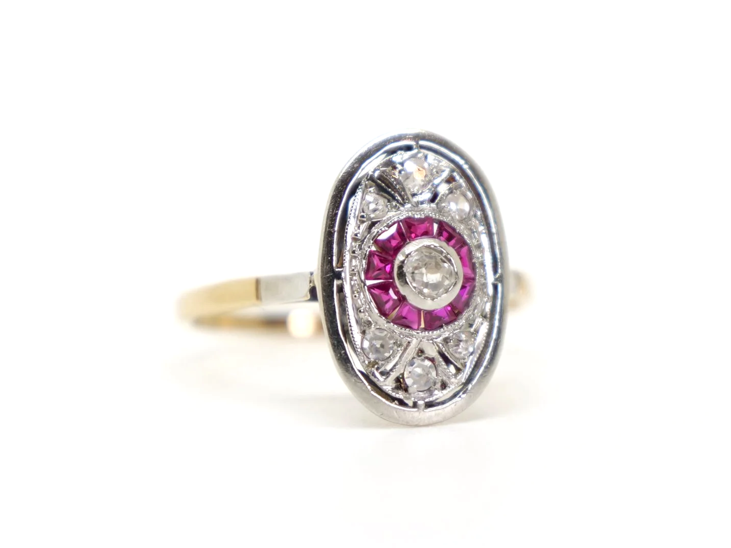 Very pretty 18ct gold and platinum Art Deco ruby and diamond ring, set with a lovely central old cut diamond, with further diamonds in the oval setting. Step cut rubies around the centre diamond.