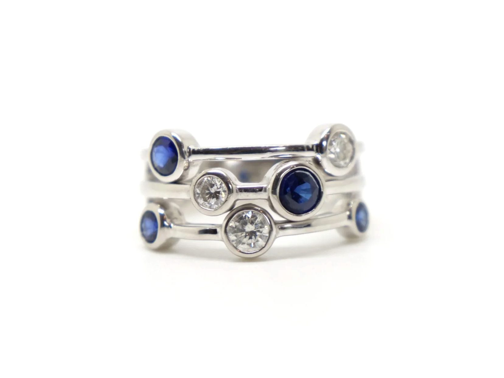 Beautiful platinum sapphire and diamond ring, often called a bubble ring and designed in the style of Boodles Raindance collection. Set with four sapphires and three diamonds.