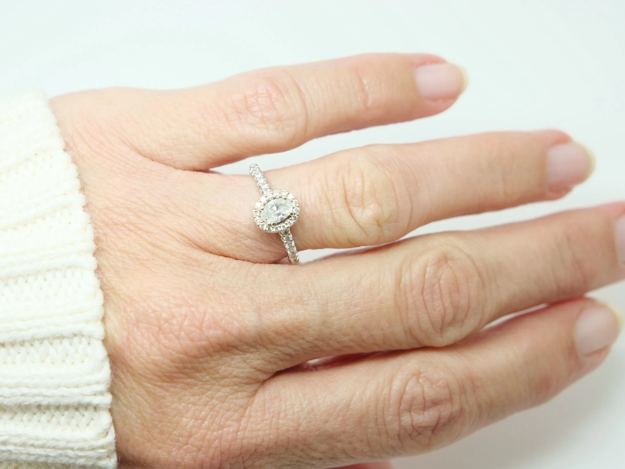 Very sparkly 18ct gold oval diamond halo ring, set with a central oval cut diamond of 0.33cts, and surrounded by a diamond halo. Further diamonds to each shoulder. Total 0.53ct diamonds.