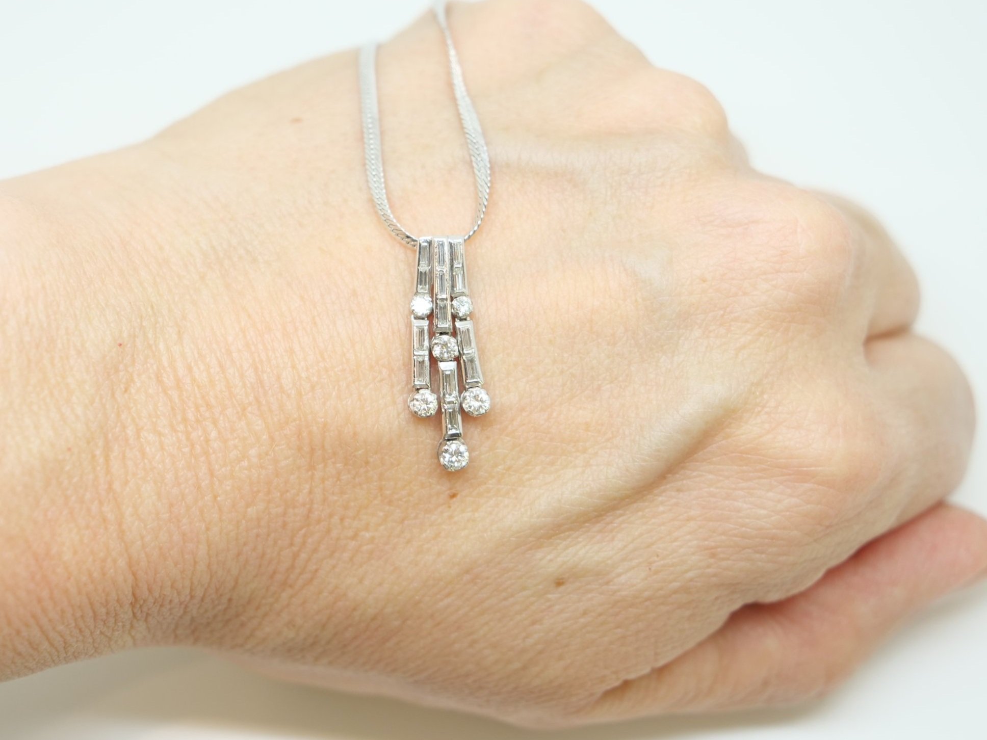 Superb platinum diamond waterfall design pendant, set with a mixture of brilliant and baguette cut diamonds. With platinum chain.