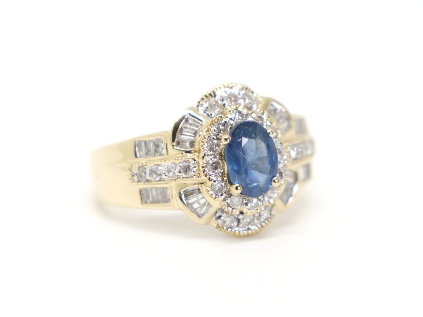 Statement design 14ct gold sapphire and diamond ring, set with a central mid blue 1ct sapphire and surrounded by a mix of brilliant and baguette cut diamonds.