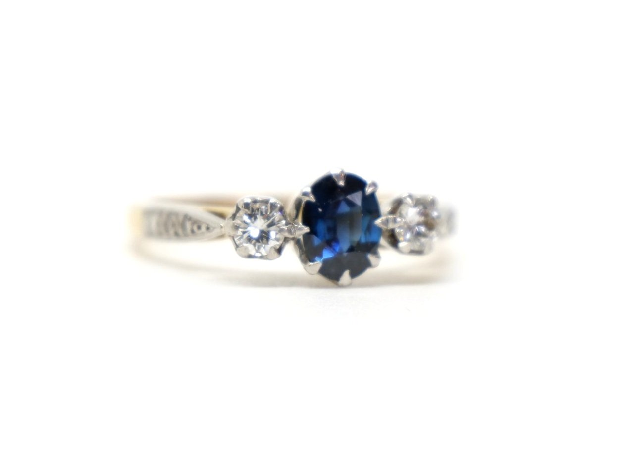 Super vintage 18ct gold sapphire and diamond trilogy ring, set with a central oval cut sapphire, woth a diamond to each side. Further diamonds to each shoulder.