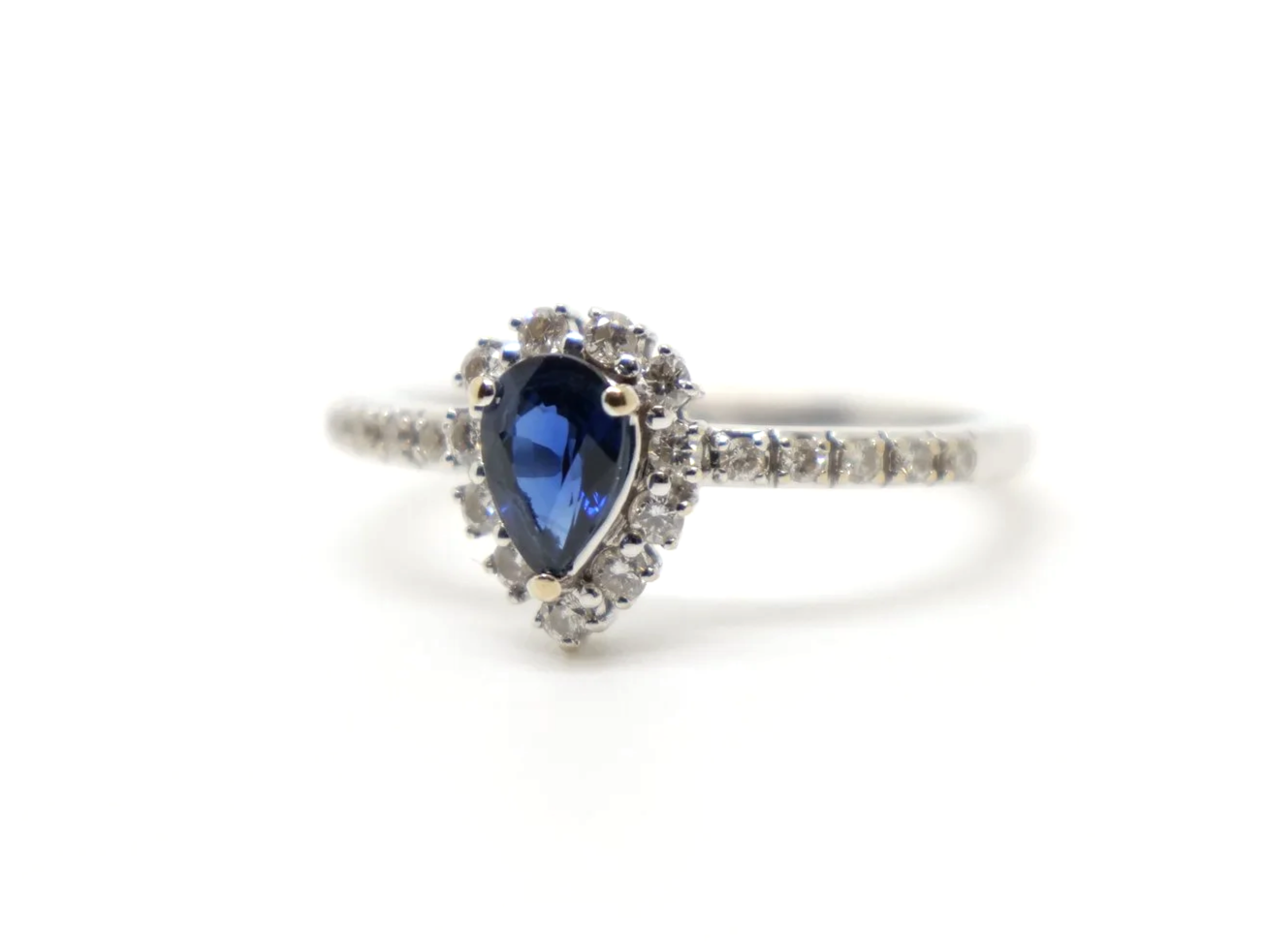 Lovely contemporary 18ct gold pear cut sapphire and diamond ring, with further diamonds set into each shoulder.