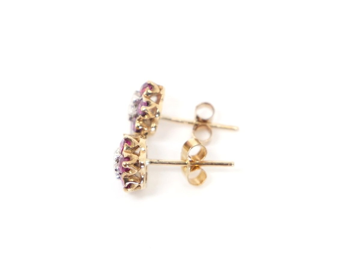 Beautiful ruby and diamond flower earrings in 9ct gold, each set with six round cut rubies and a single central diamond.